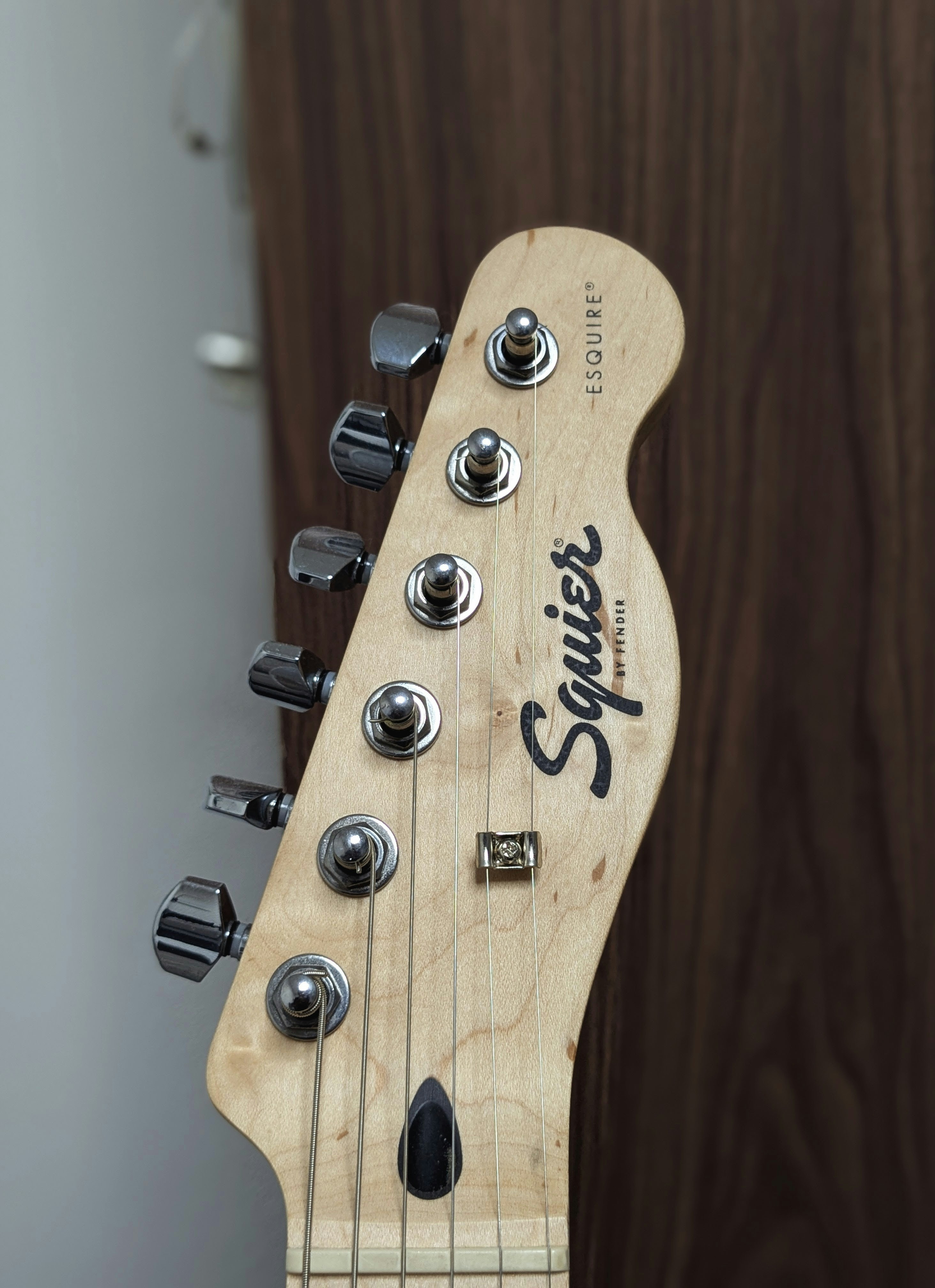 Berikut adalah keterangan singkat untuk gambar: headstock gitar squier esquire ditampilkan.