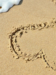 A heart is drawn in sand.
