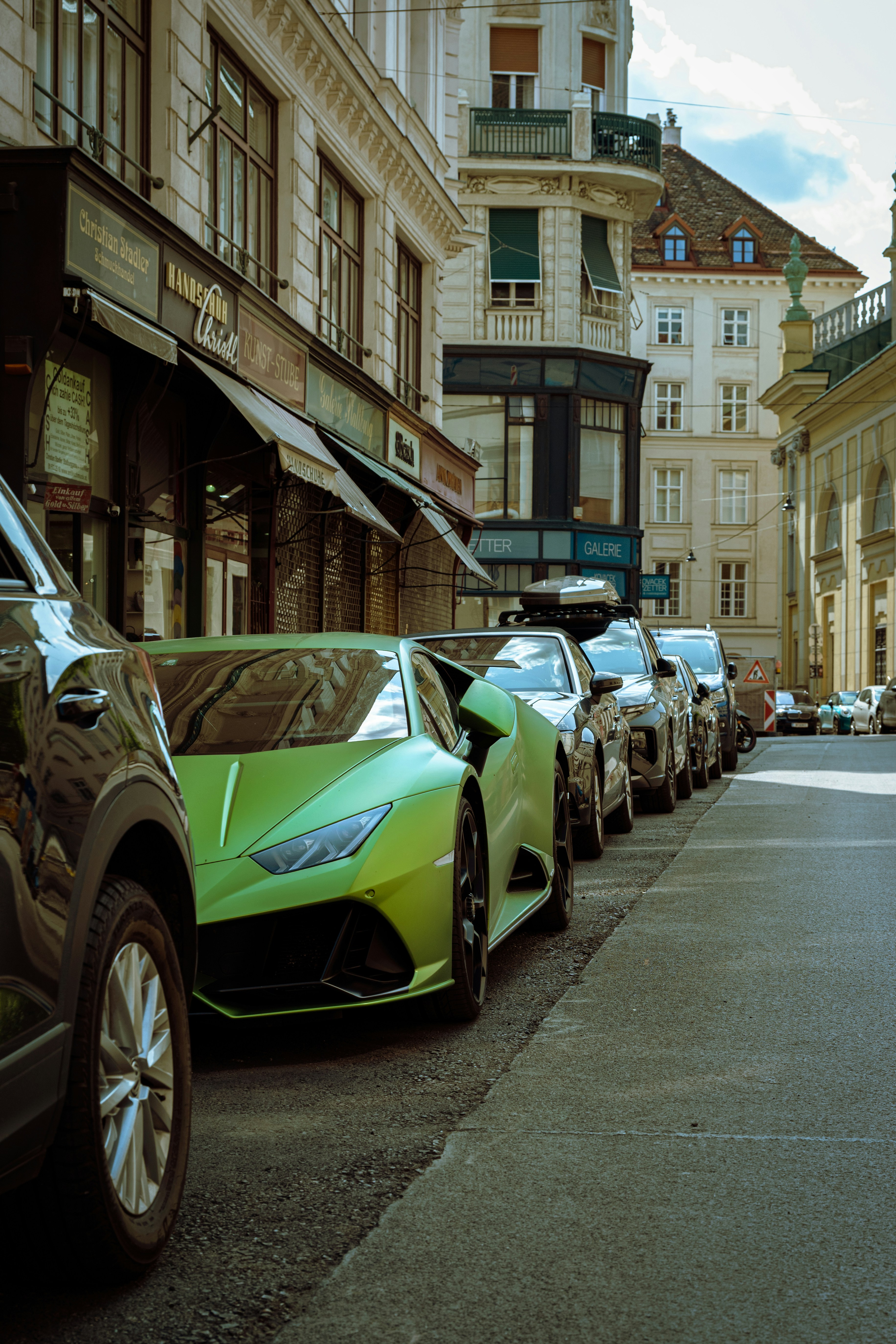 A green lamborghini is parked on a city street.