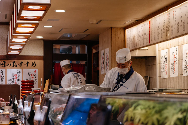 Itamaes preparando piezas detrás de la barra de un restaurante japonés