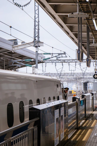 A bullet train waits at a station platform.