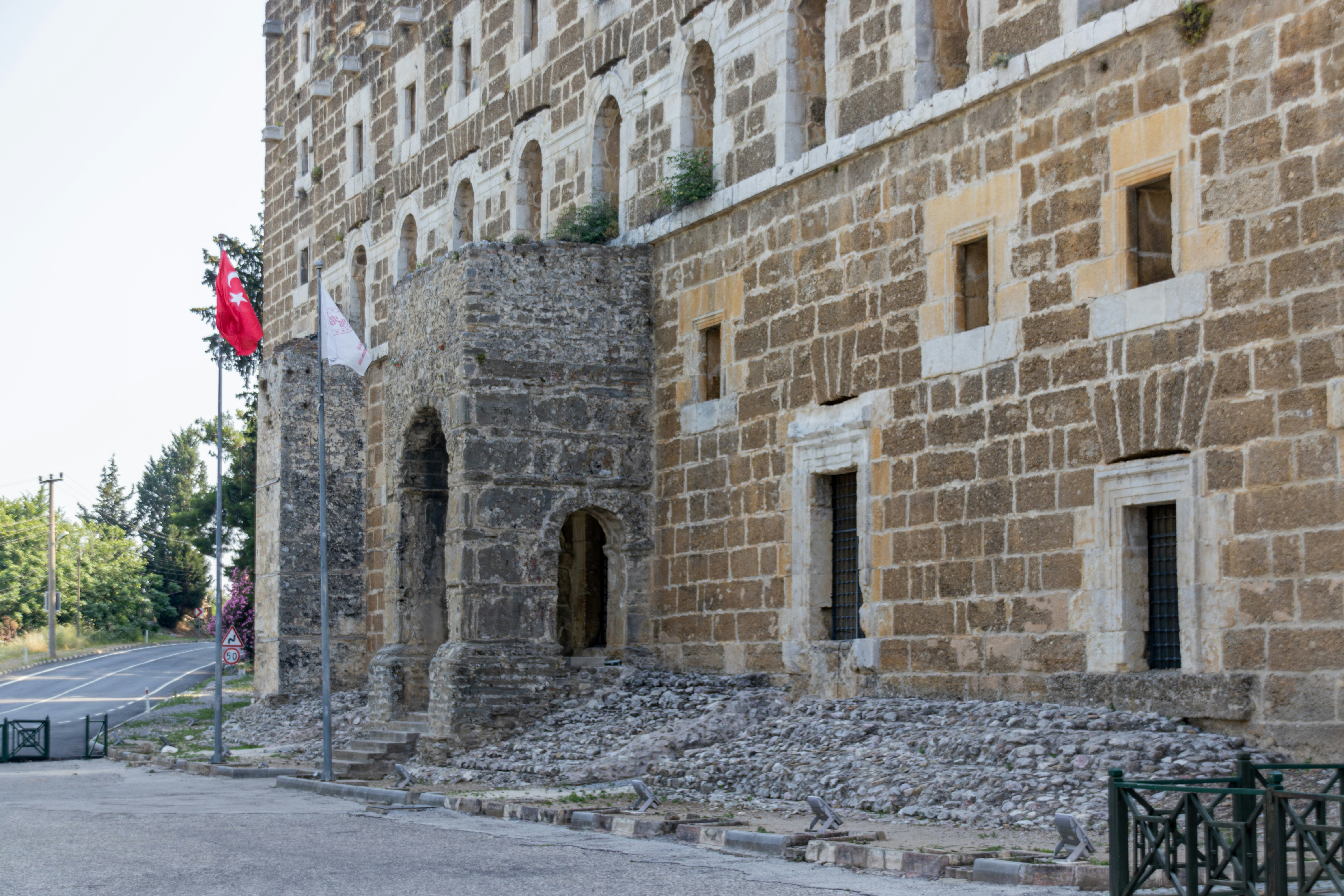 A weathered stone building with arches and windows.