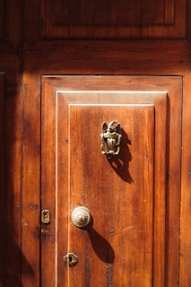 A vintage wooden door with ornate hardware.