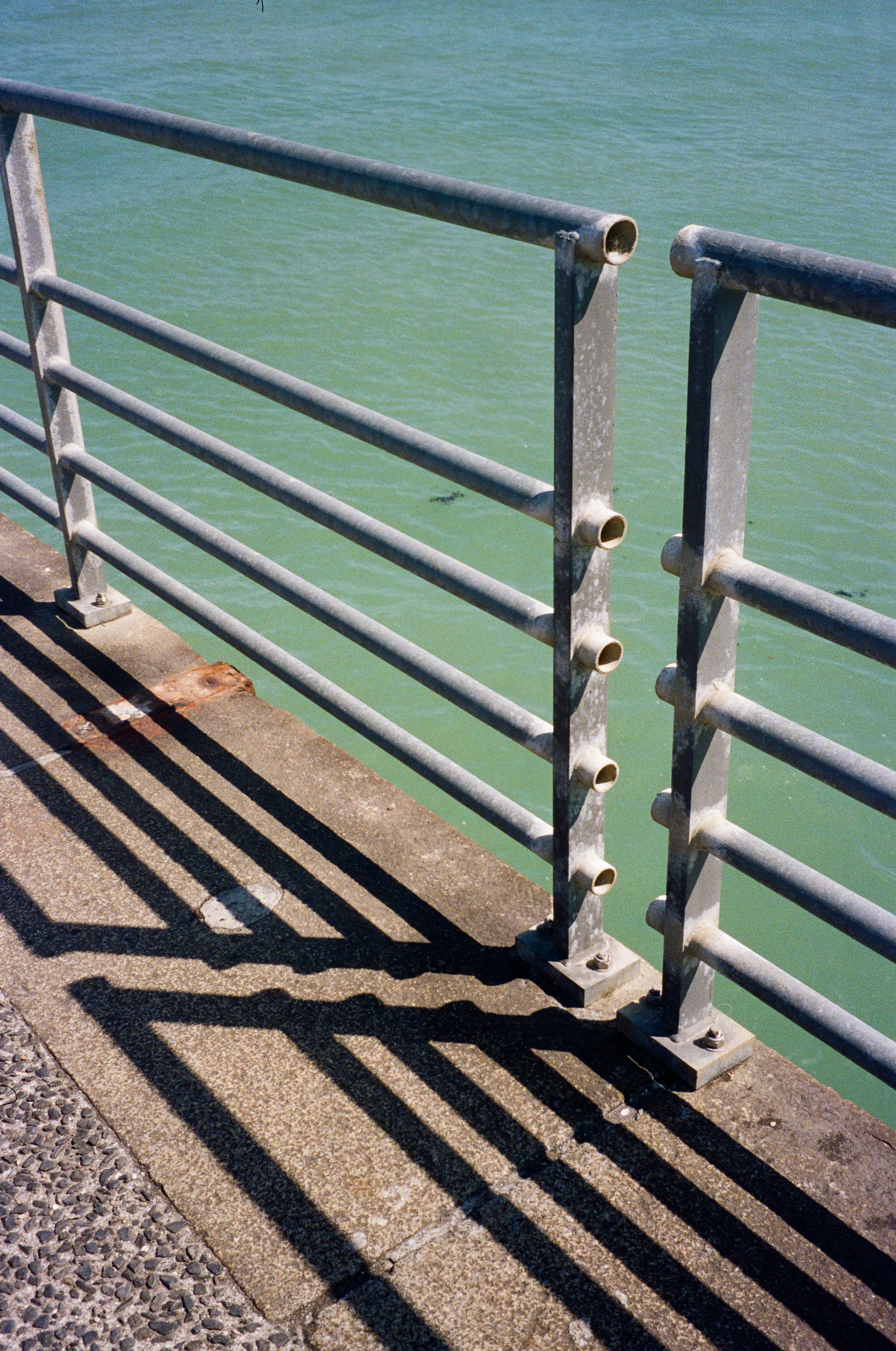 Metal railing casts a shadow on the concrete.