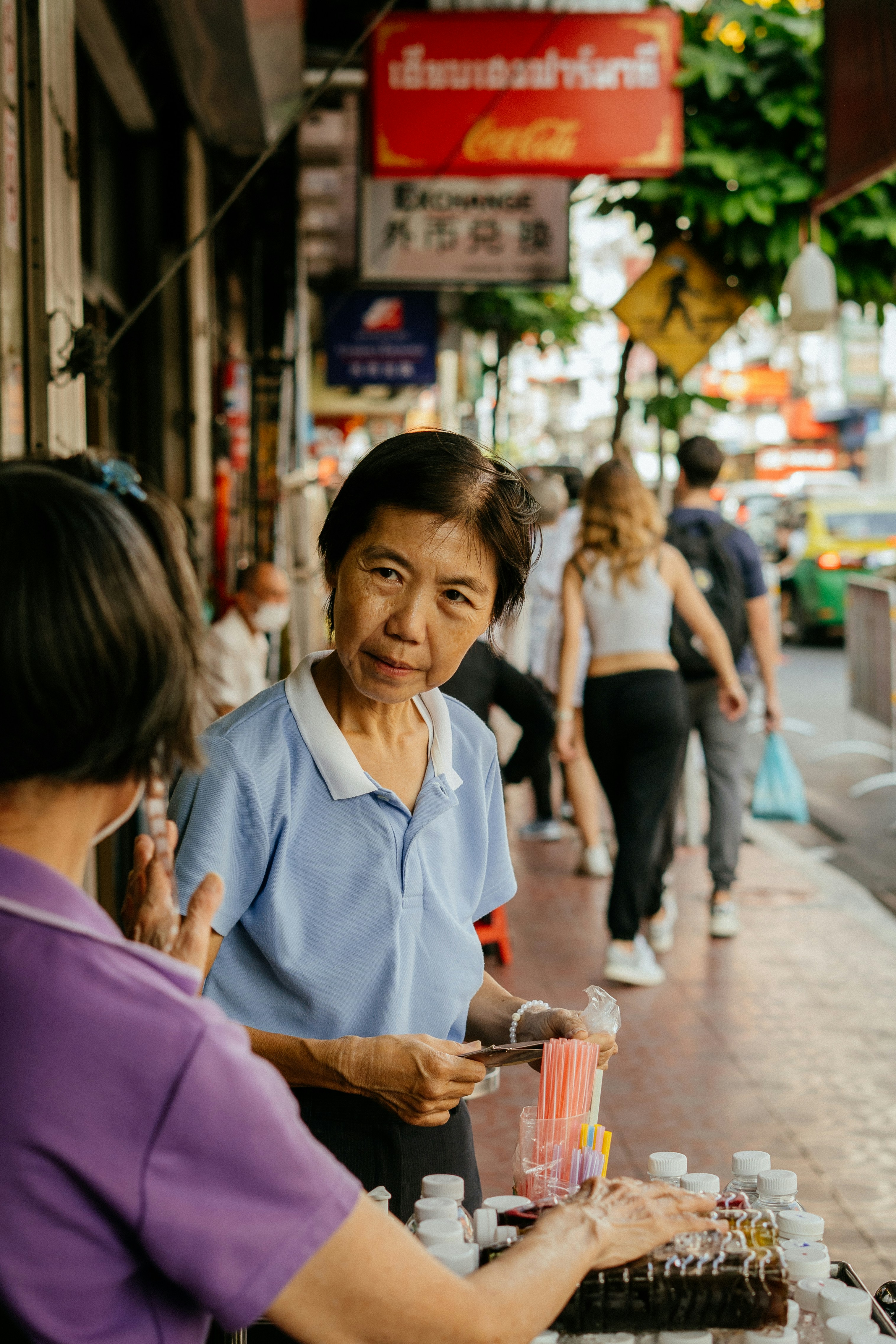 An elderly woman in thailand sells goods.