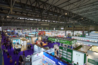 An indoor exhibition hall is full of vendors.