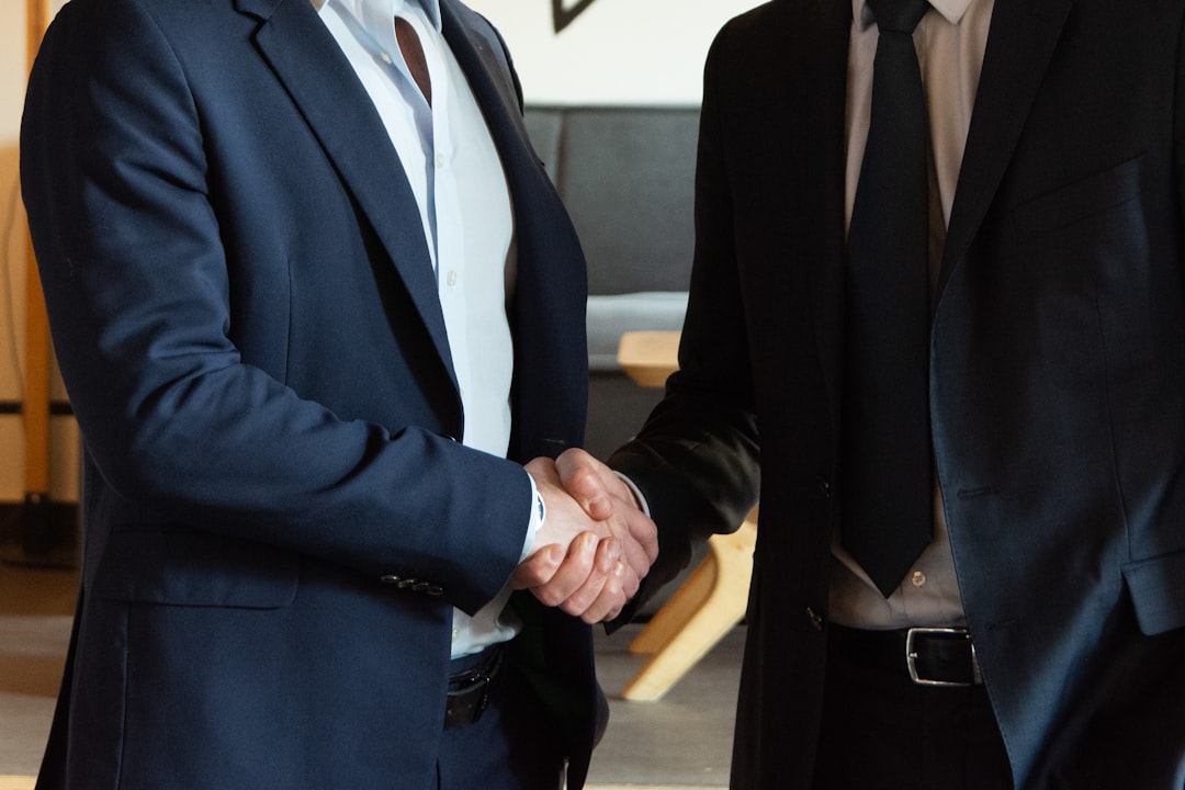 A confident lawyer shaking hands with a client - what does a workers compensation lawyer do A confident lawyer shaking hands with a client - what does a workers compensation lawyer do