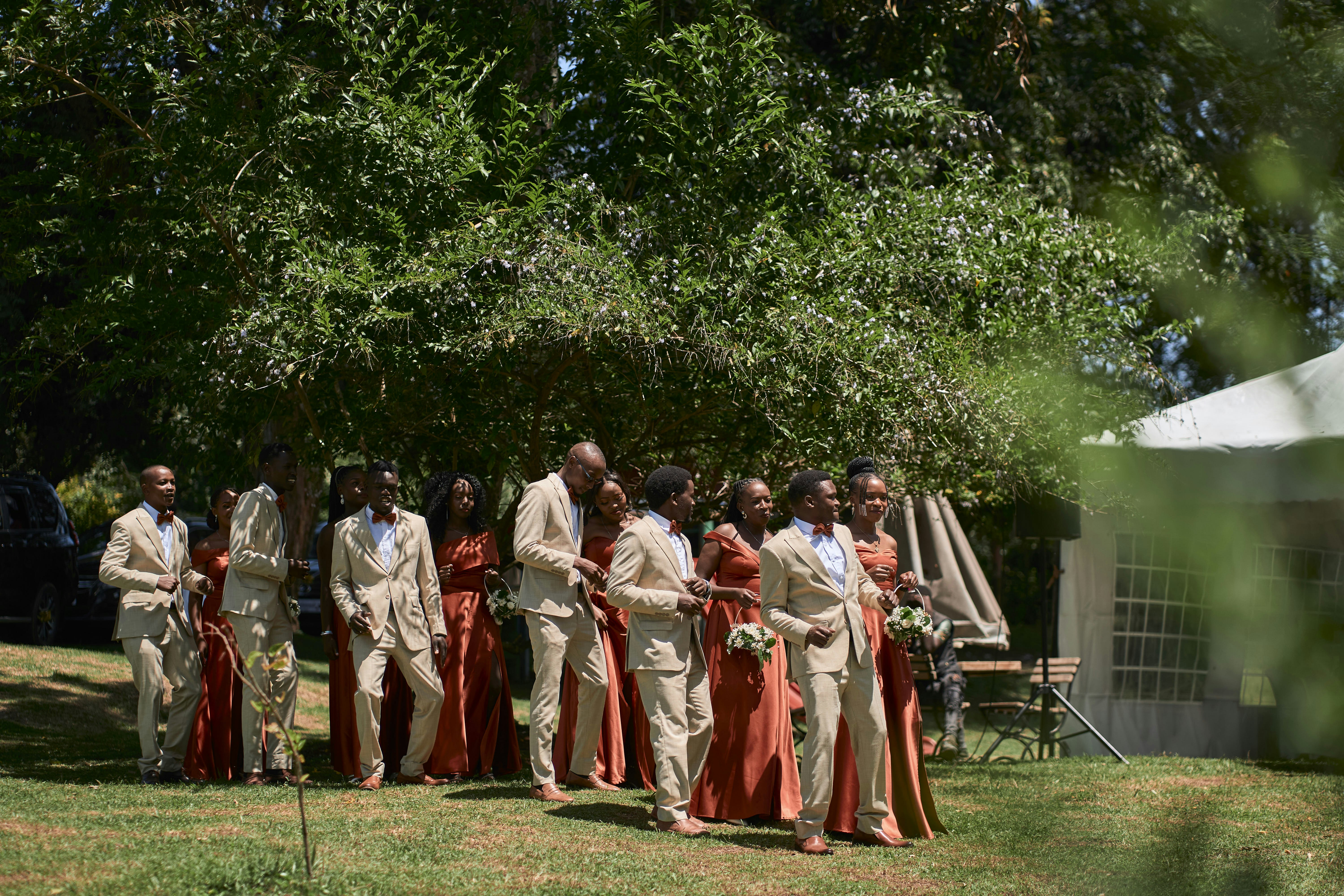 Wedding party walking together through a garden.