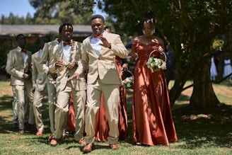 Wedding party processes down the grassy aisle.