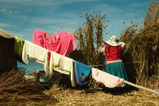 Clothes are drying on a clothesline near a woman.