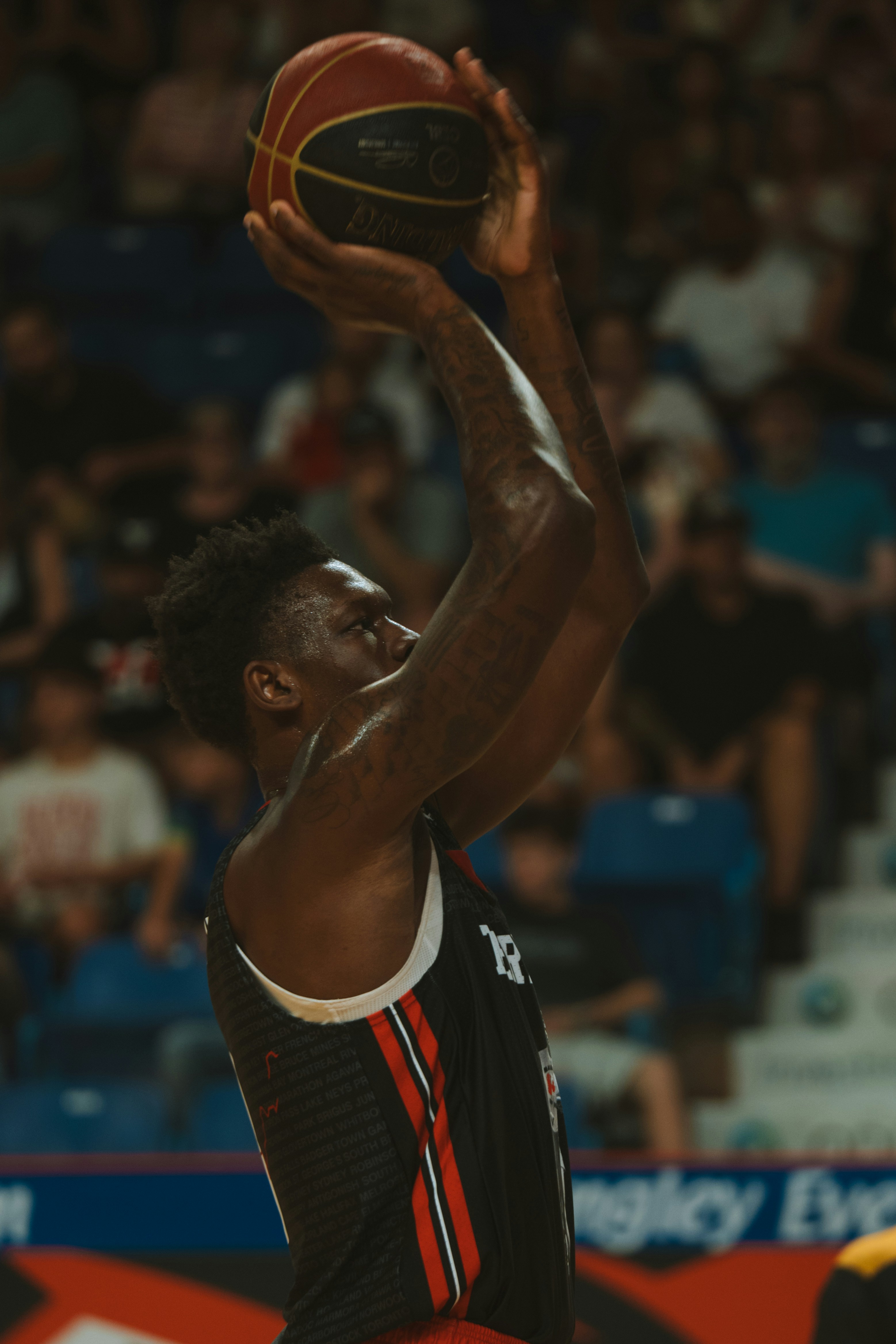 Basketballspiller holder bolden med begge hænder klar til at skyde.