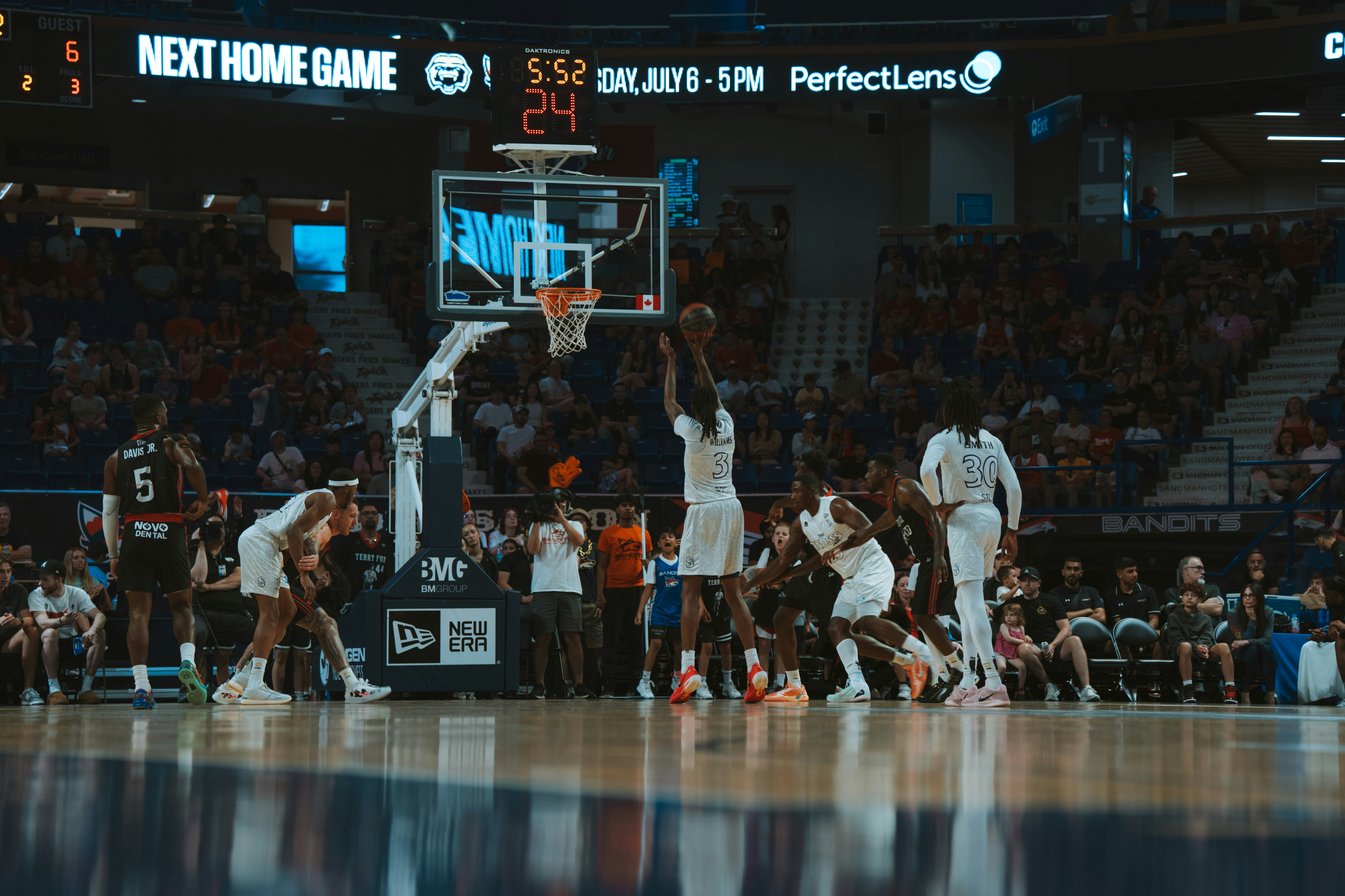 A basketball player shoots the ball during a game.