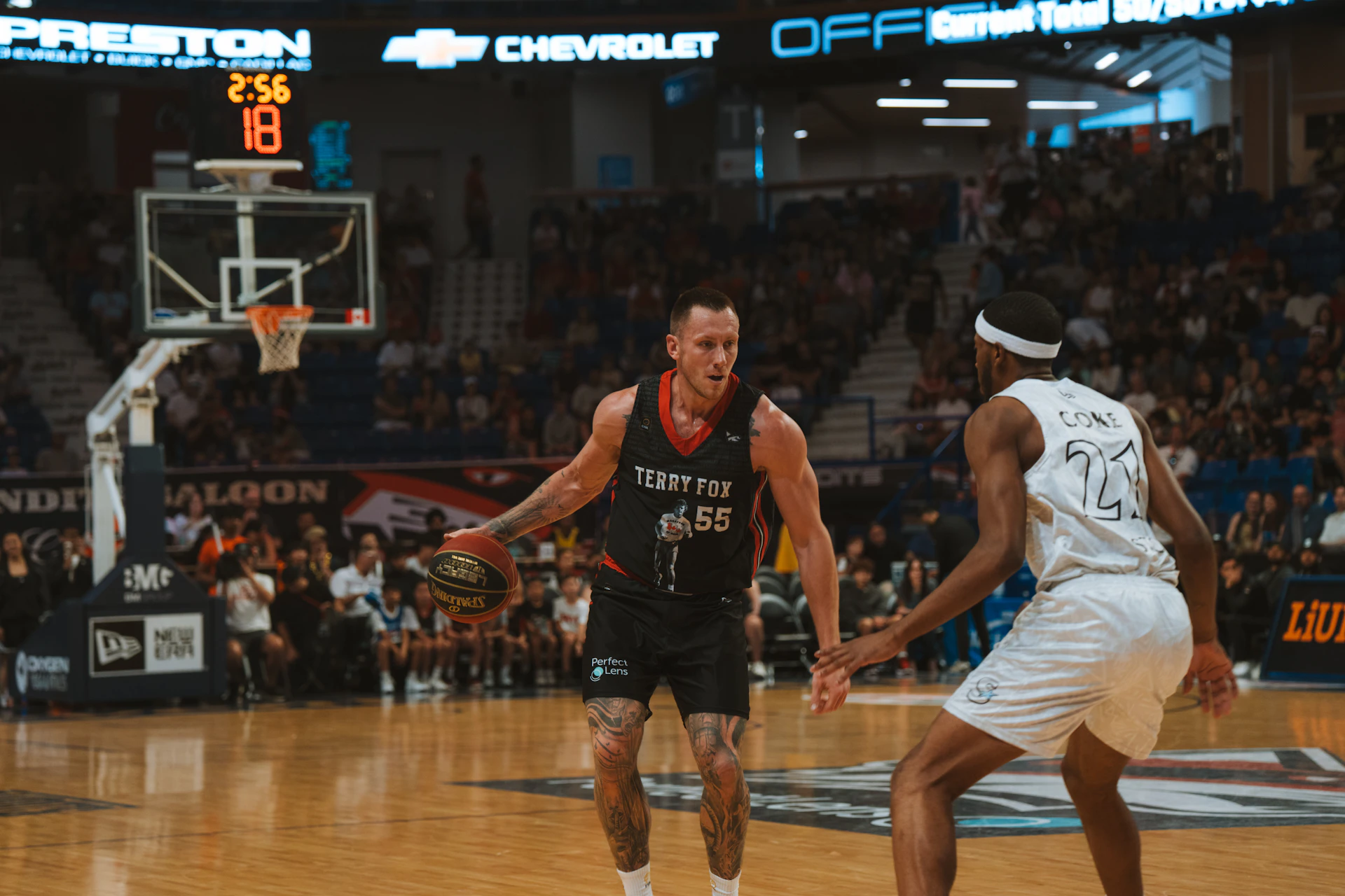 A basketball player dribbles the ball on the court.