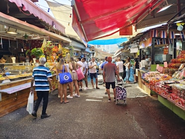 People shop and walk through a busy market.