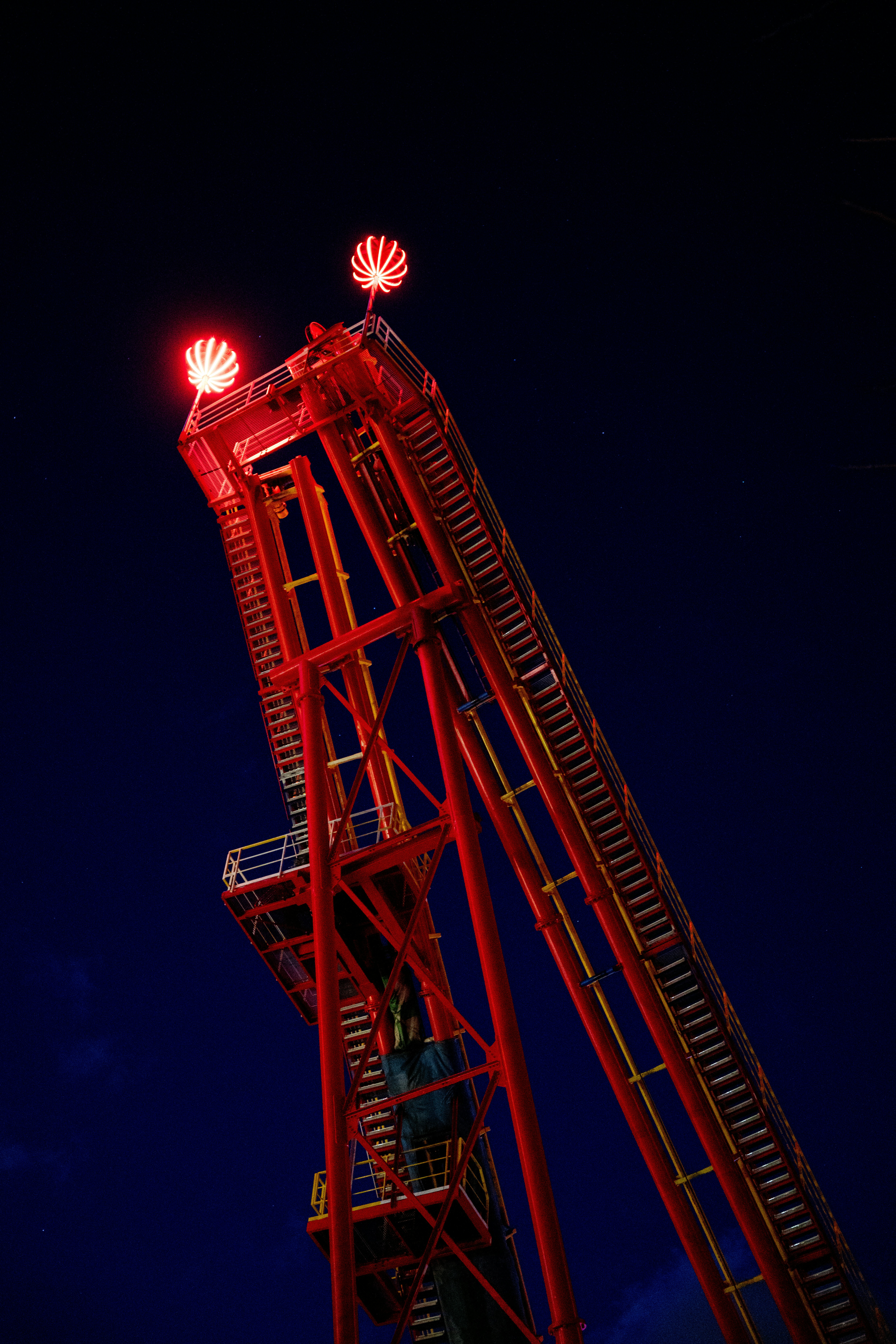 Ein rotes Bauwerk ragt gegen den dunklen Himmel empor.