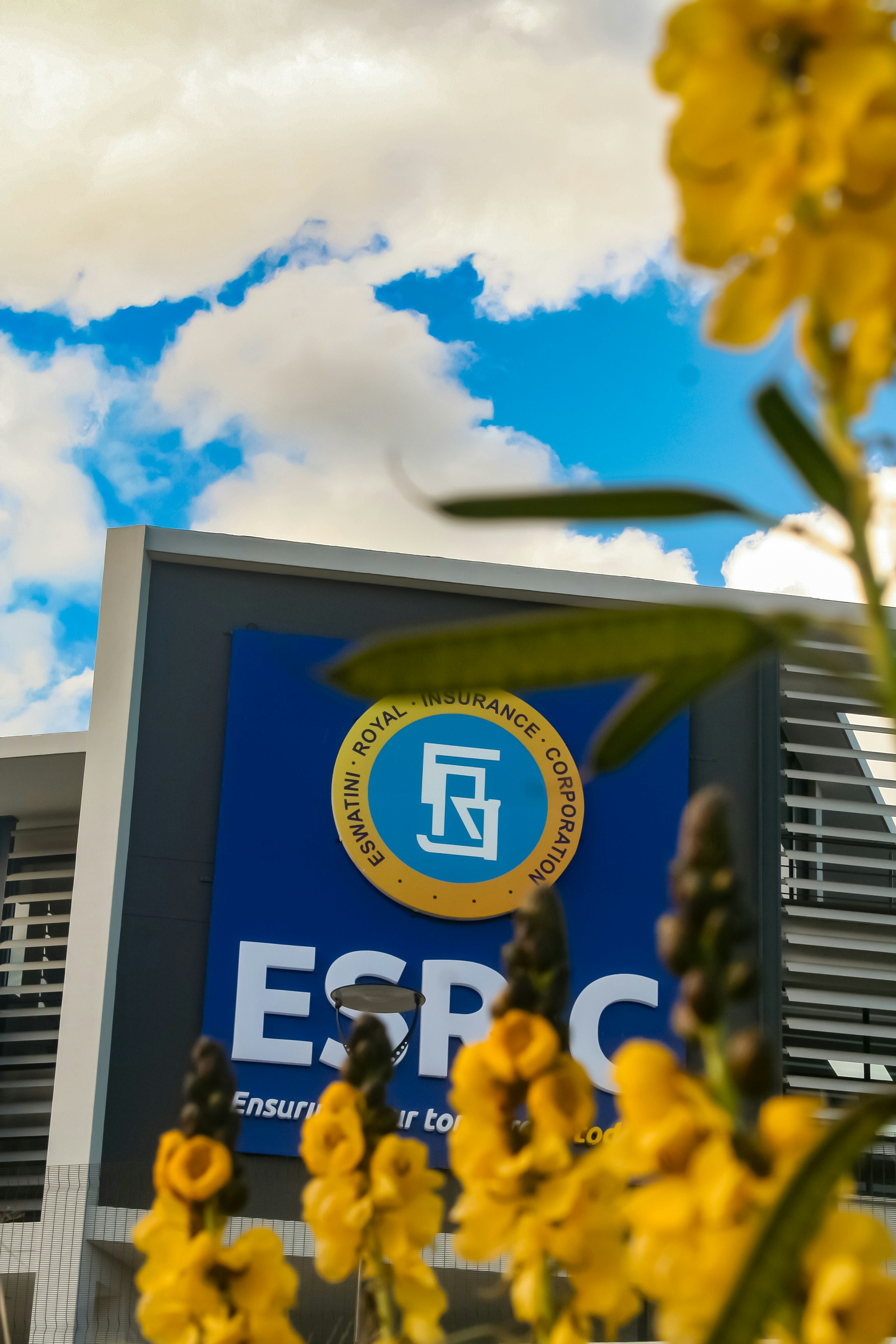 Flowers frame the esprc building under a blue sky.