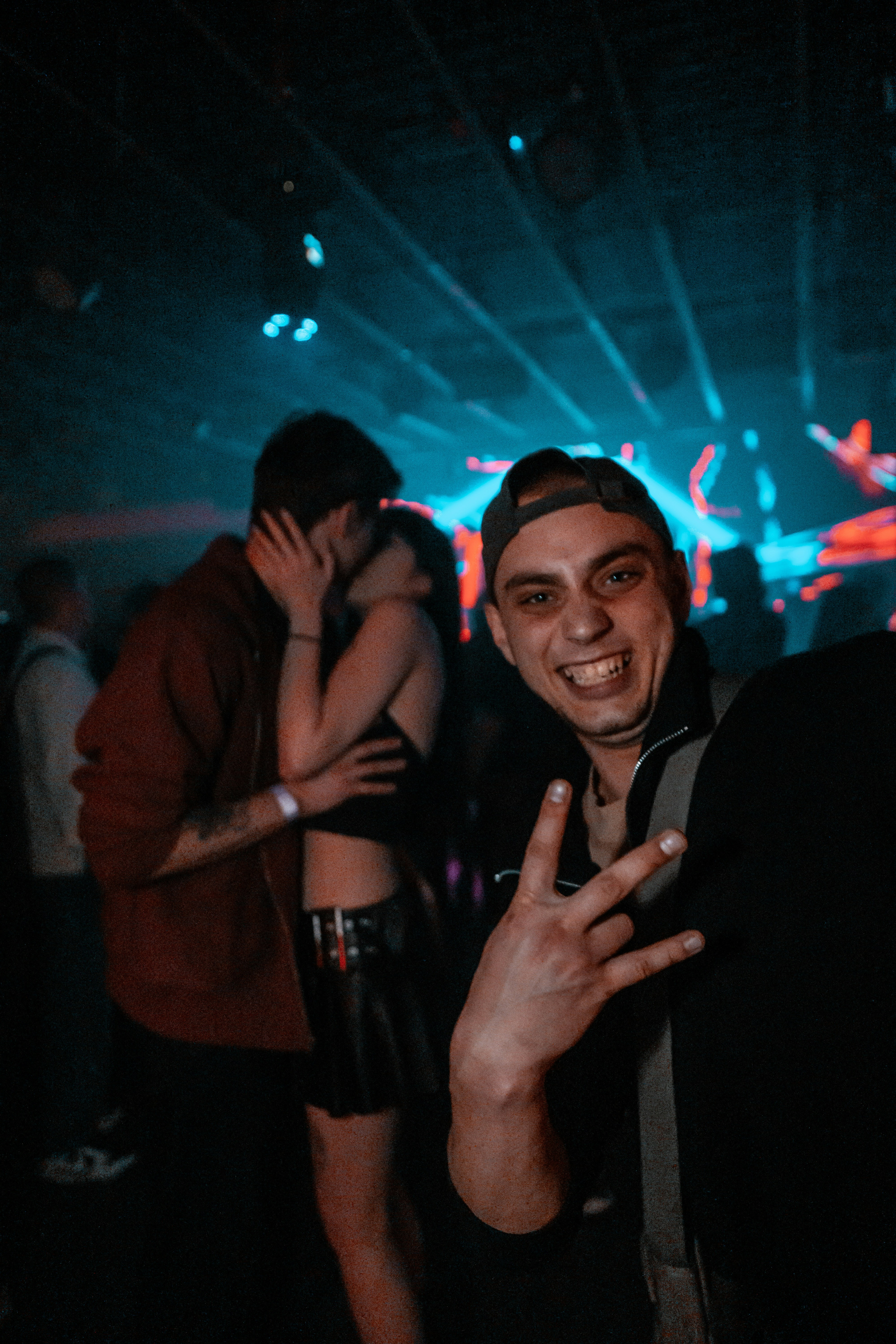 Man smiles for a selfie at a nightclub.