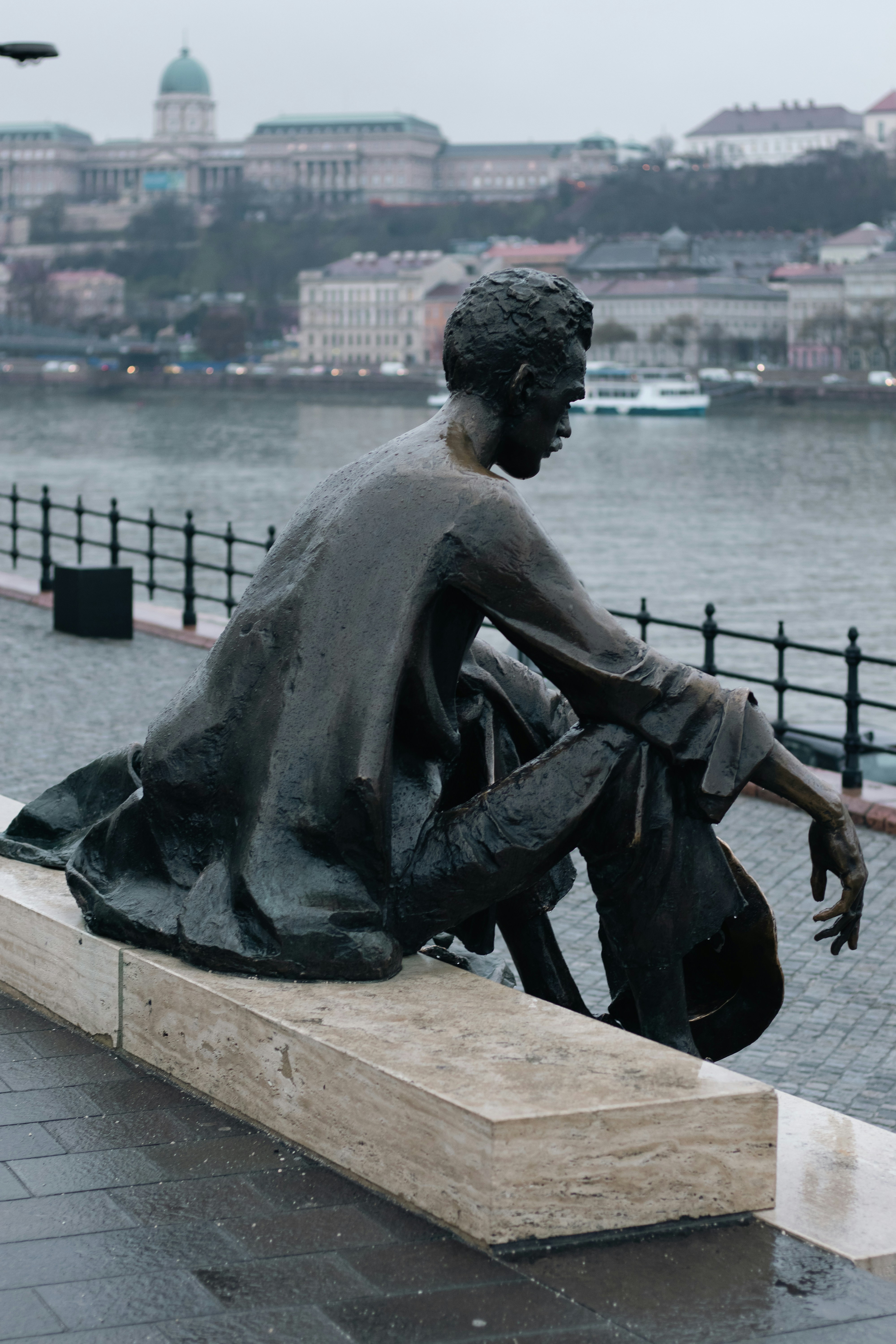 A bronze statue sits by the water.