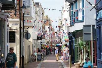 A narrow street is lined with shops and flags.