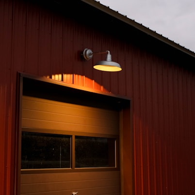 A bright barn light illuminates the garage door.