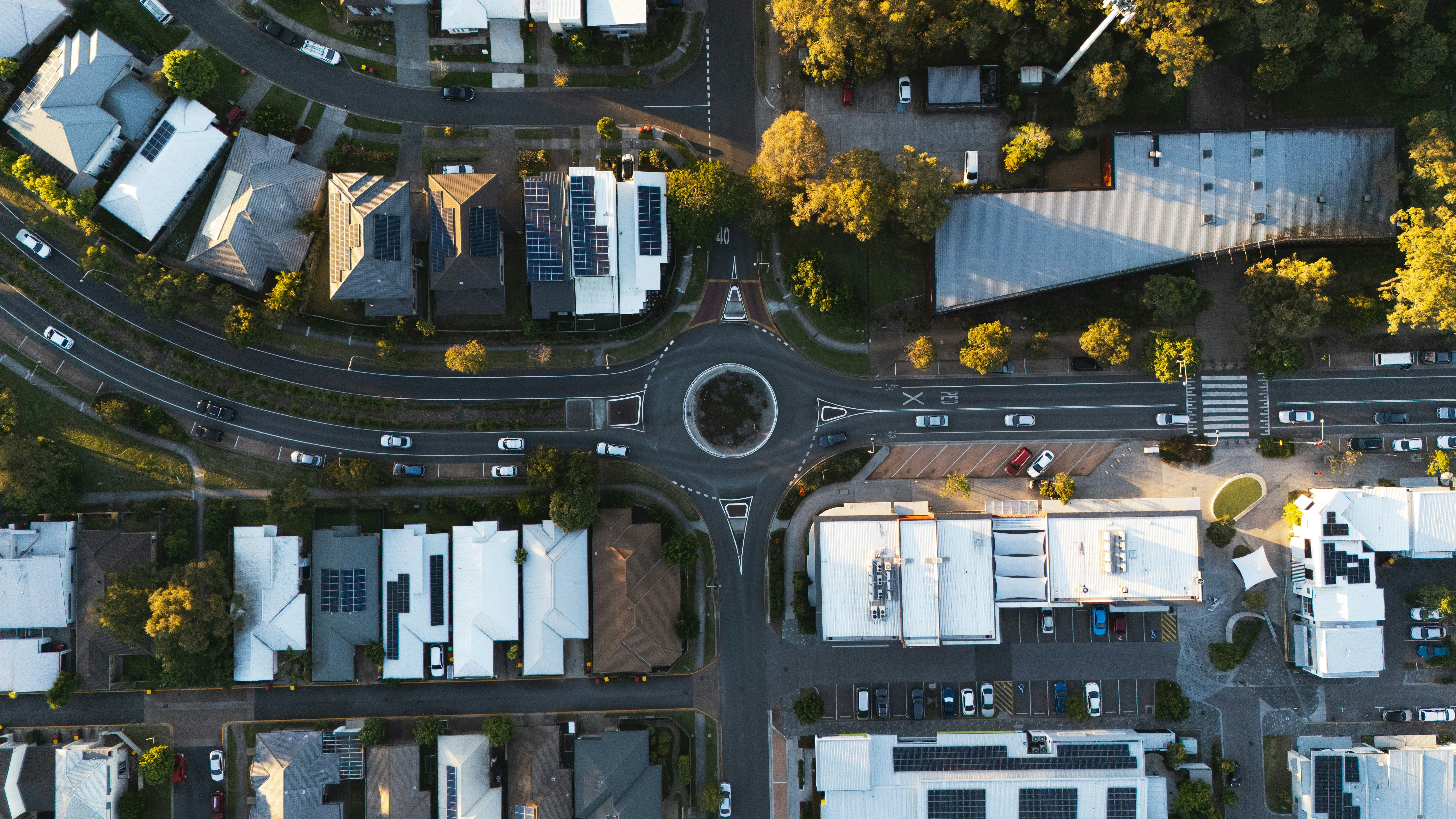 A young adult sitting on a box in a new apartment, using the EasyHome app to organize their first weekly budget and chore list.