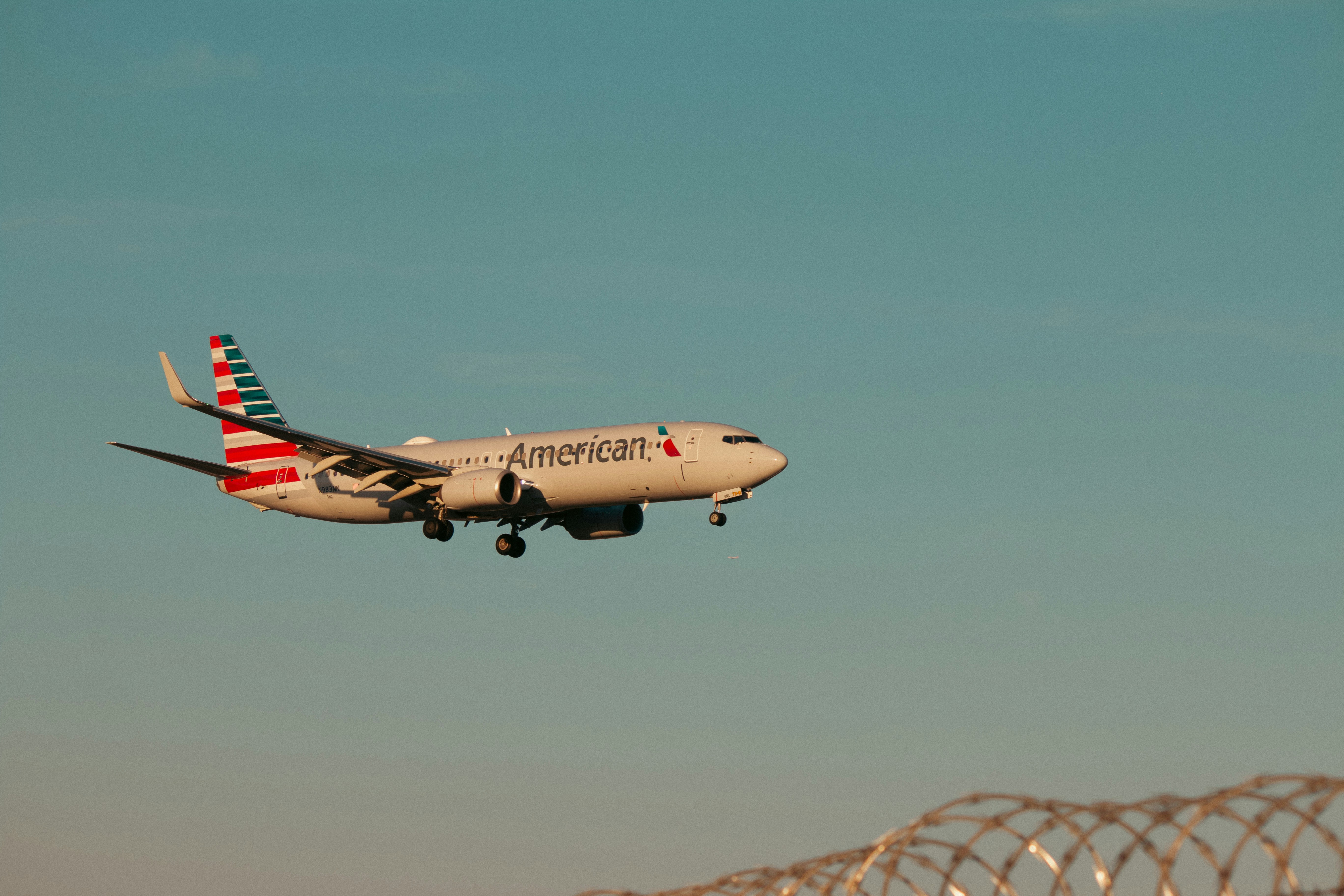 An american airlines plane flies in the sky.
