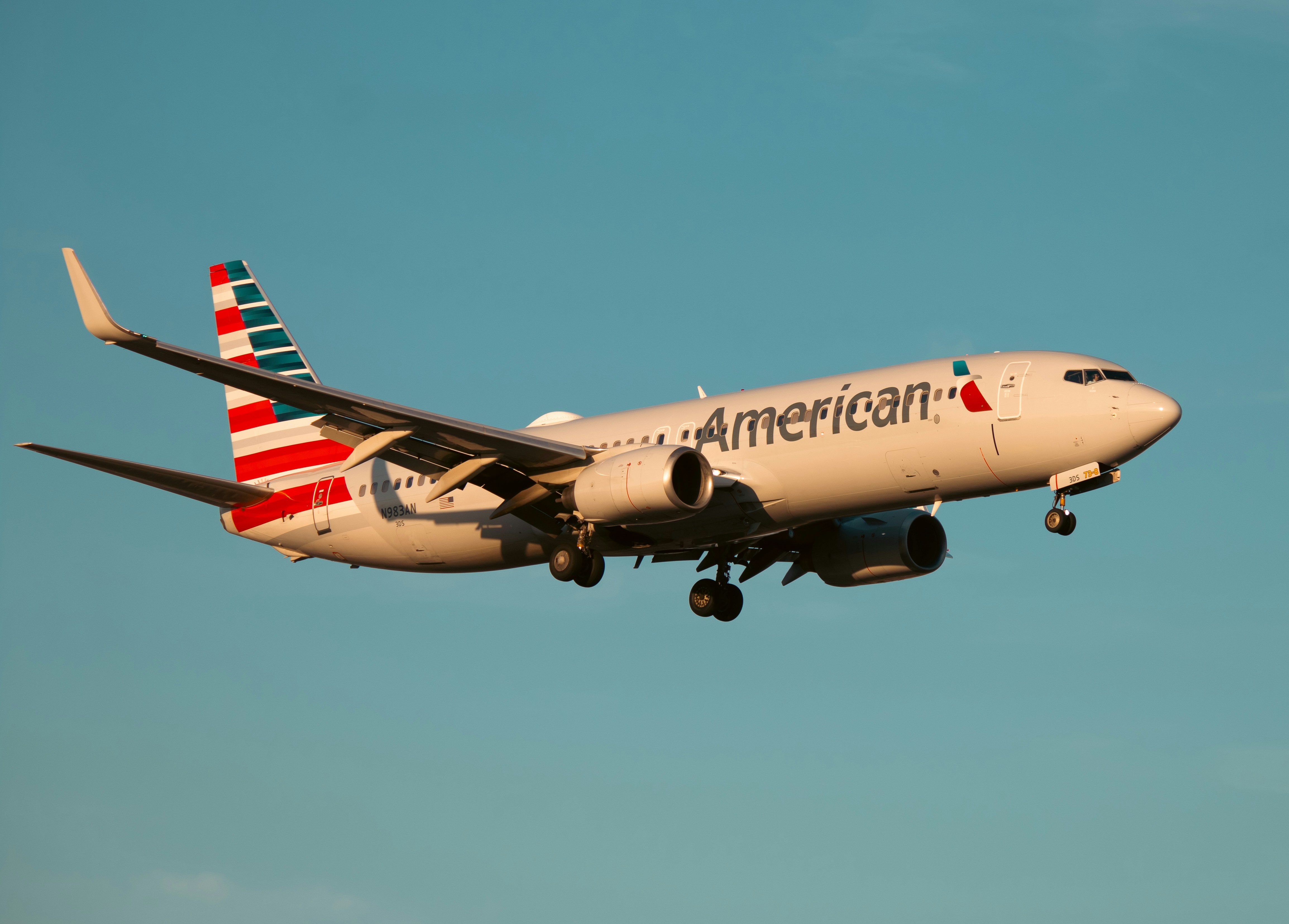 An american airlines plane is flying in the sky.