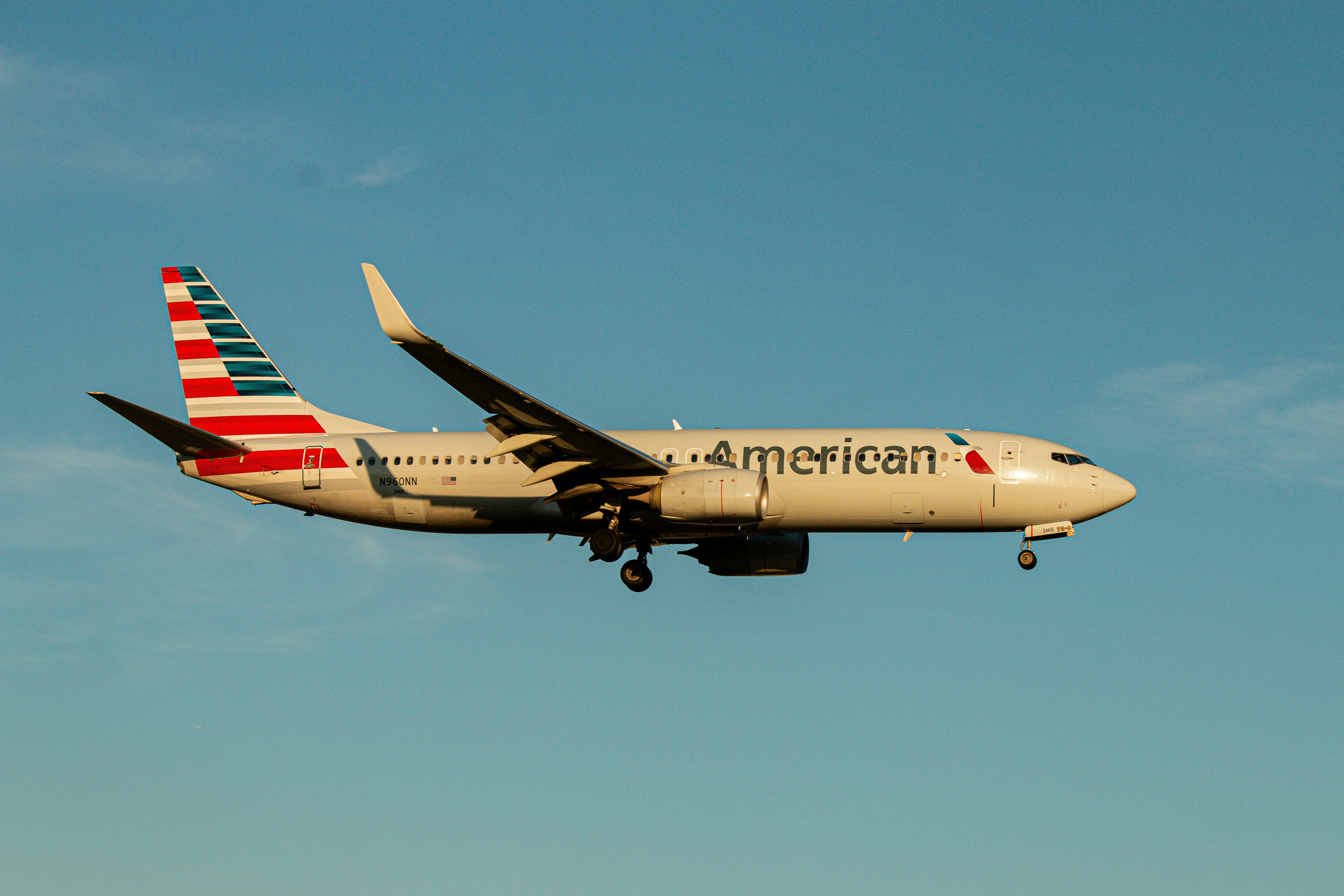An american airlines plane is flying in the sky.