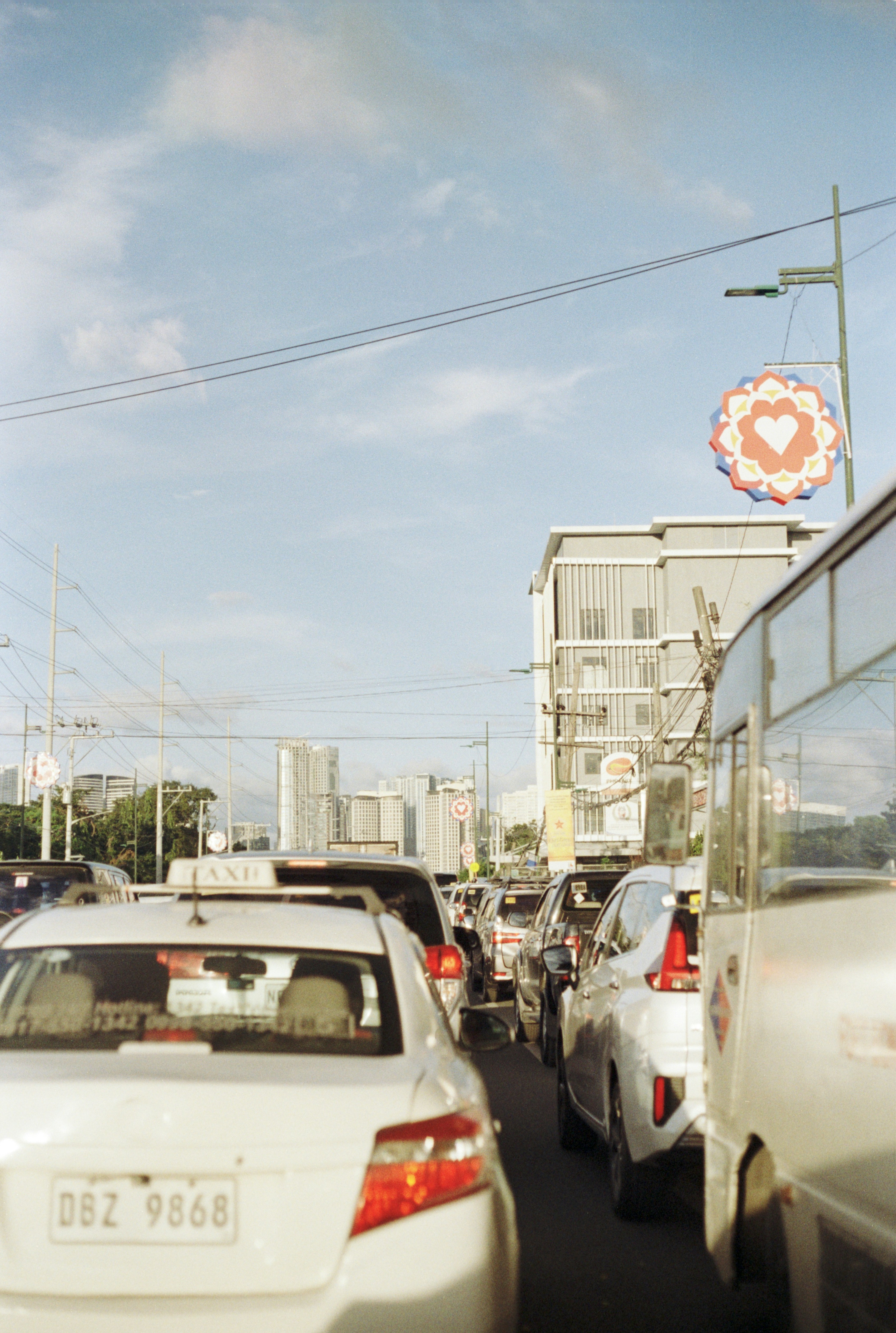 Cars are stuck in heavy traffic on a sunny day.