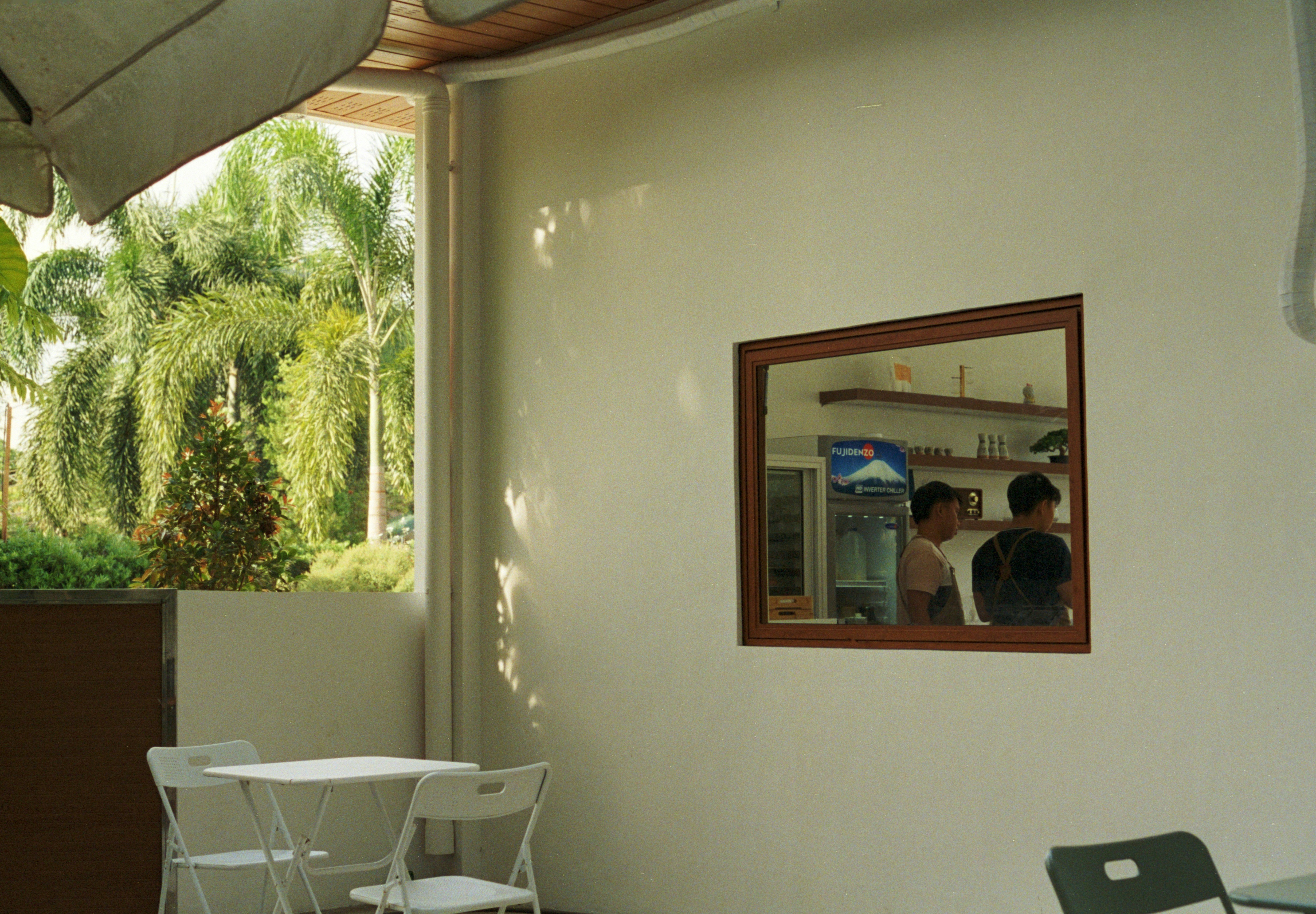 A sunny outdoor space with tables and a mirror.