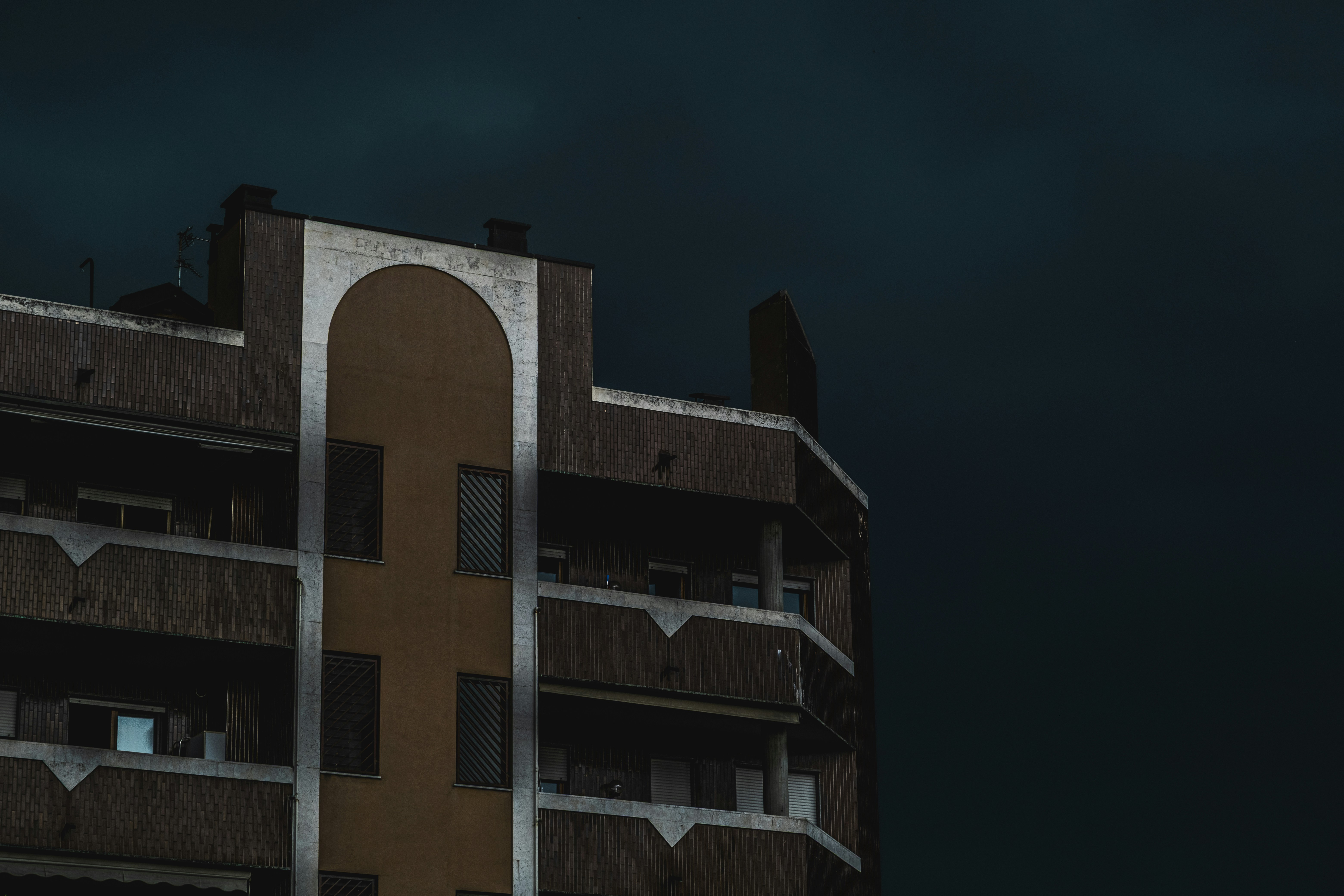A building's corner under a dark blue sky.