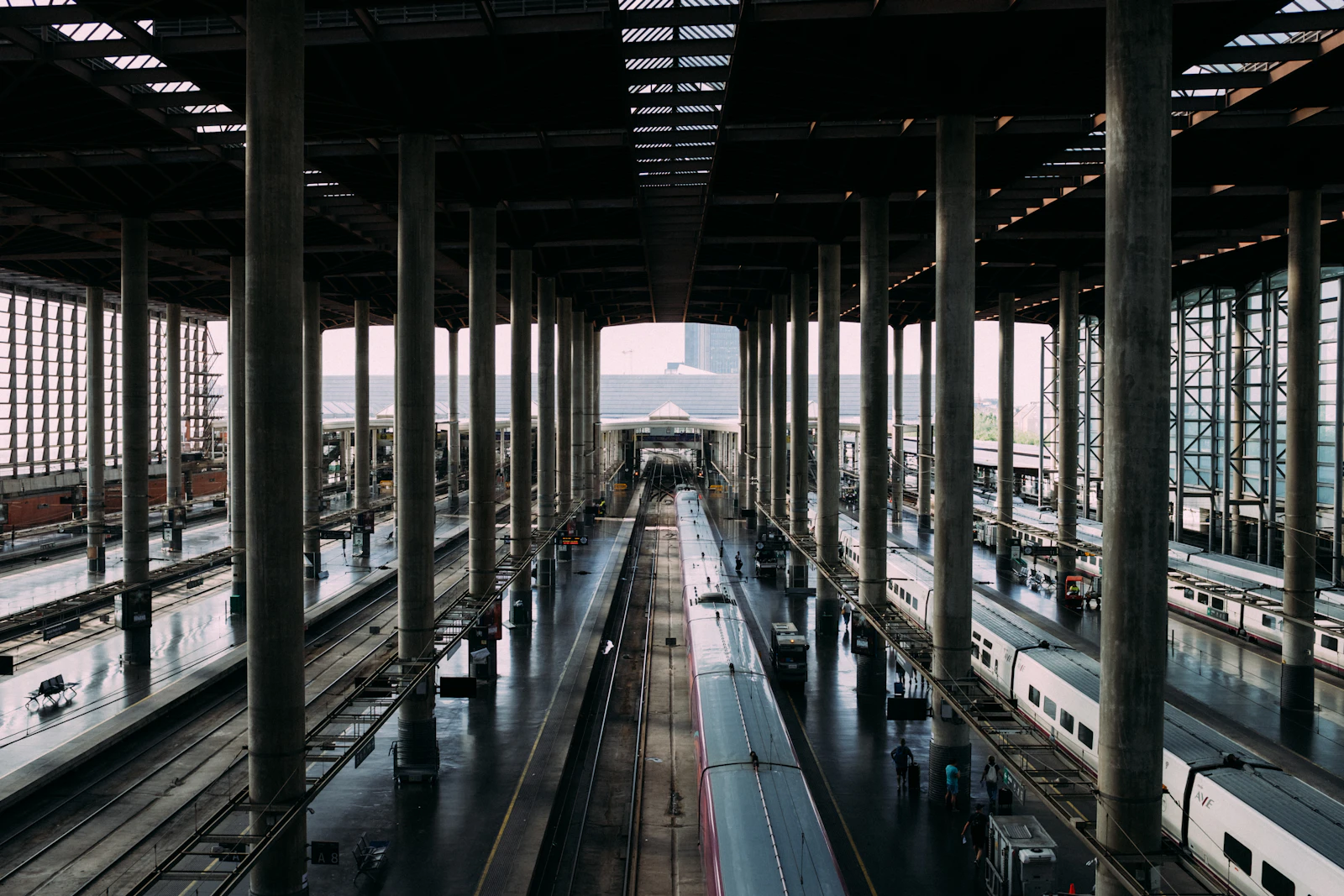High-speed trains lined up beneath a large covered station in Madrid