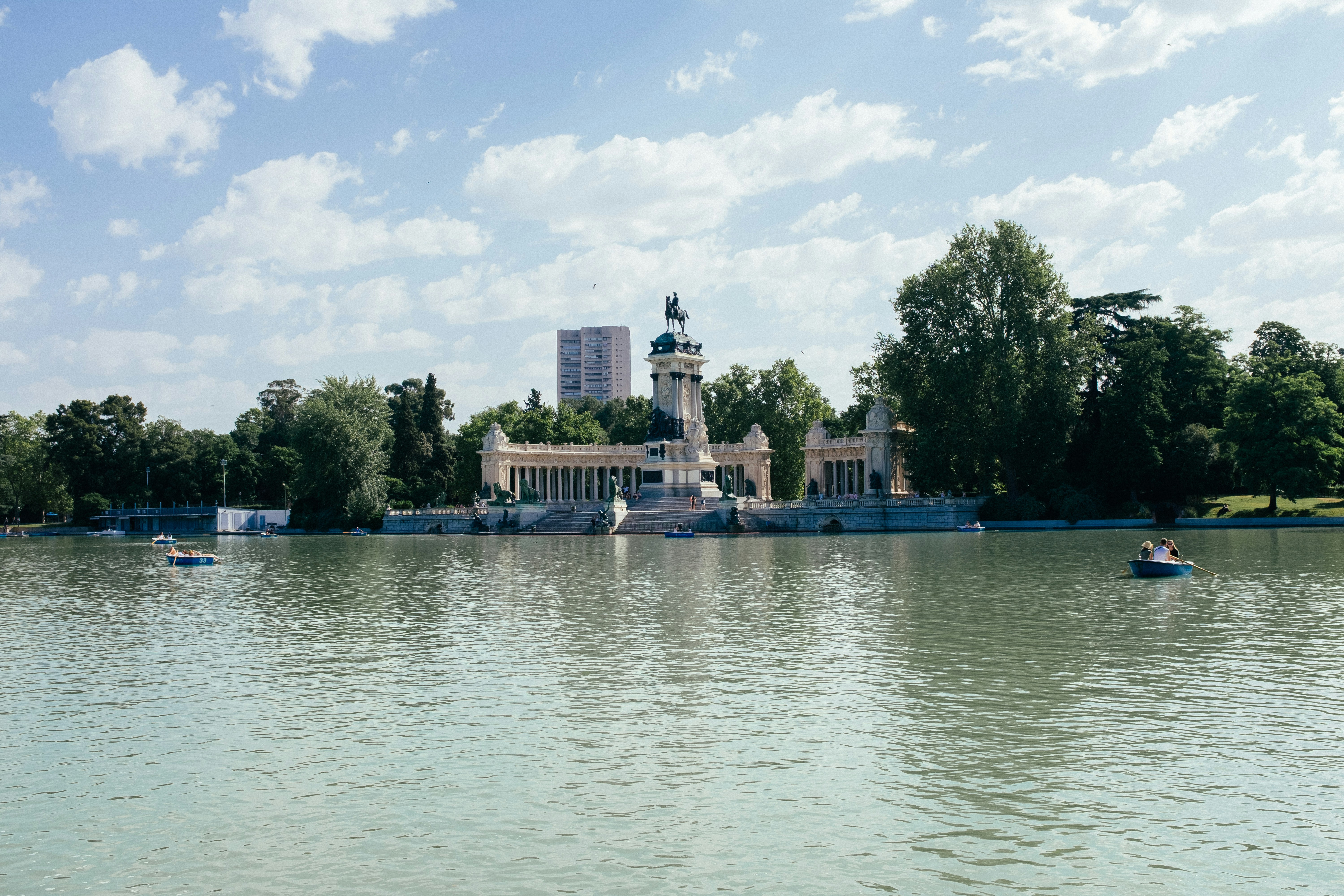 Boats float on a lake in front of a building.