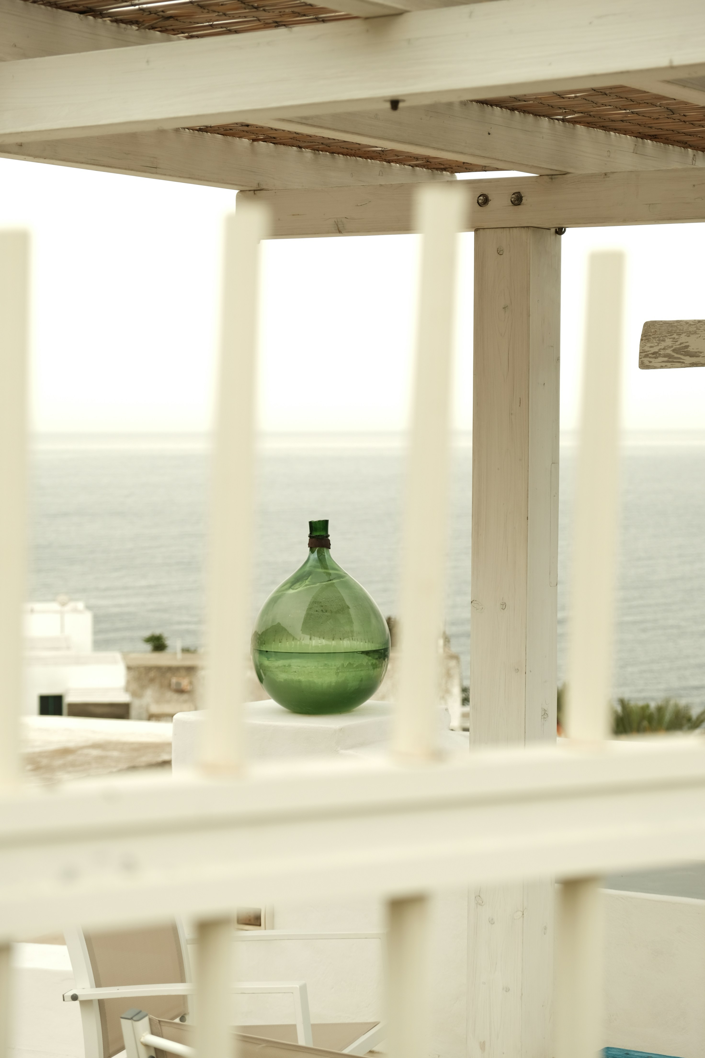 Une bouteille en verre vert se trouve au bord de la mer.