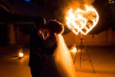 Newlyweds share a kiss with a fiery heart.