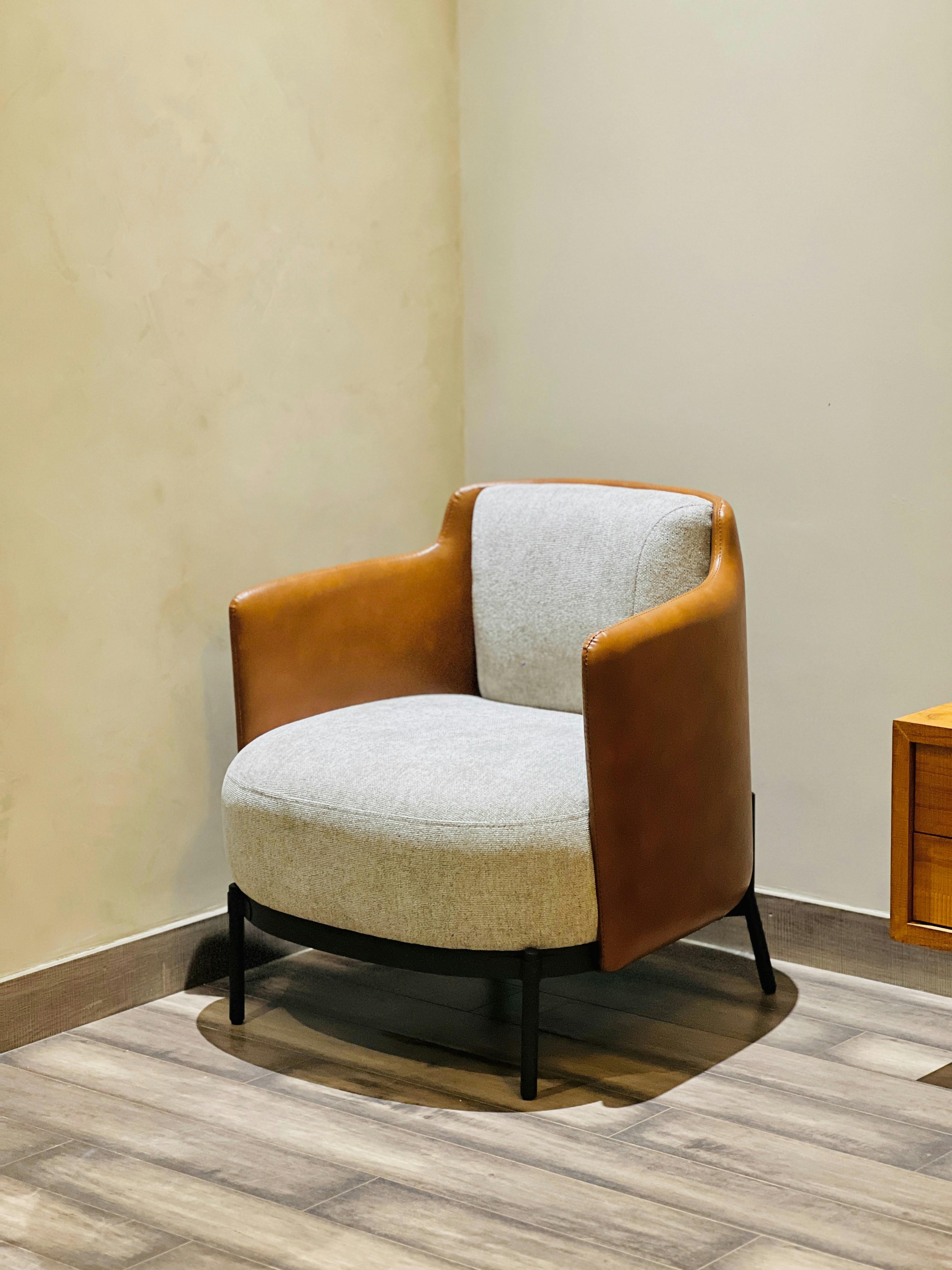 A brown and white armchair in a corner.