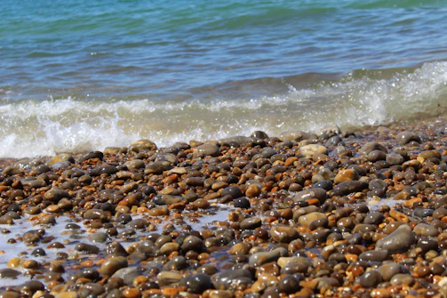 Waves gently wash over a pebble beach.