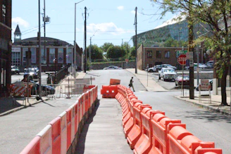 Roadwork and barriers block a city street.