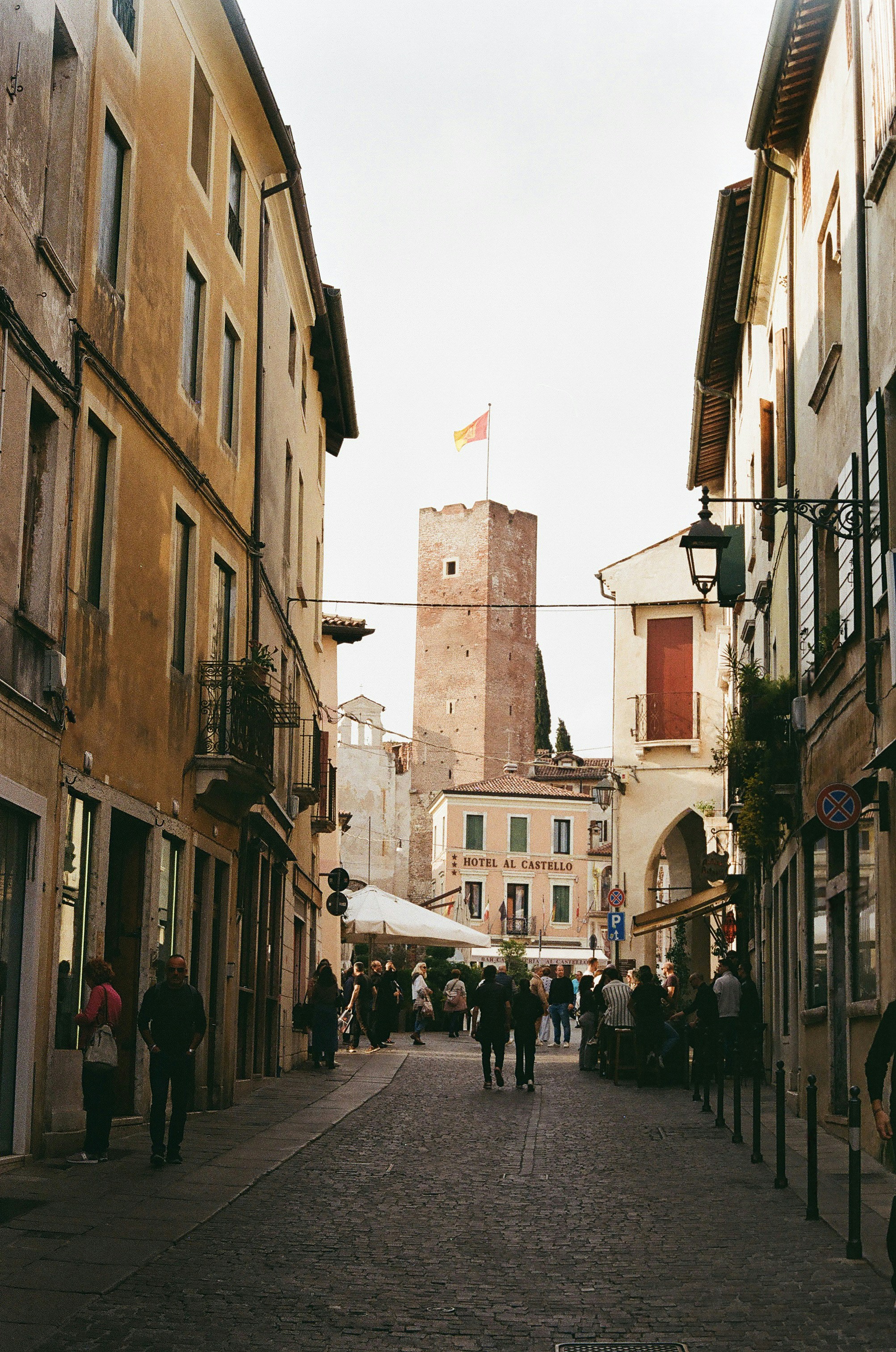 Une rue européenne avec des boutiques et une tour.