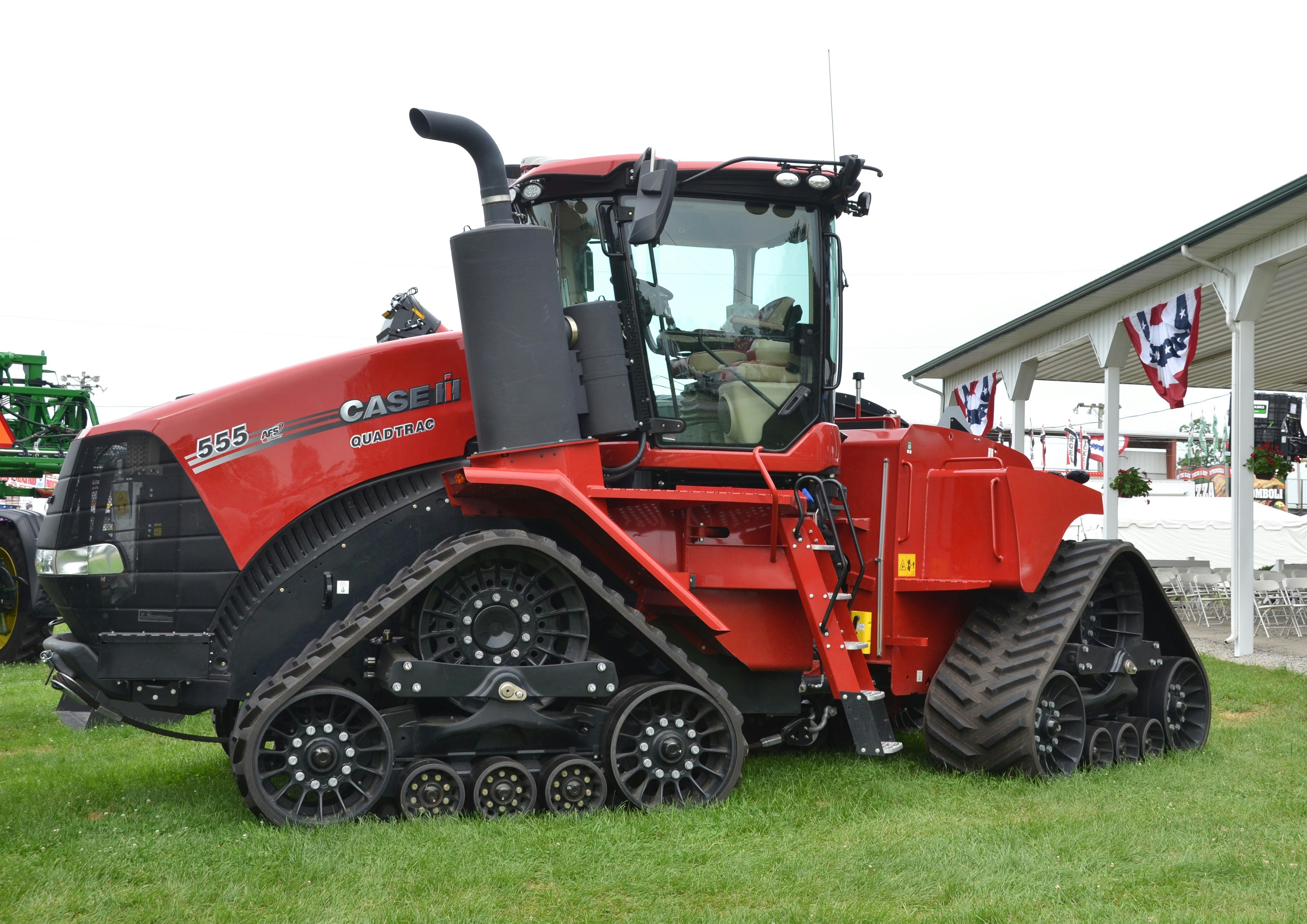 A red tractor with tank tracks is shown. photo – Free Human Image on ...