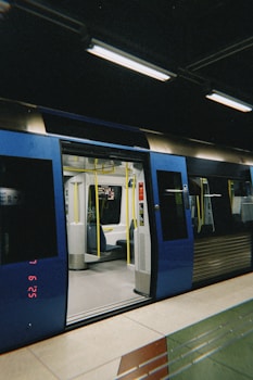 A subway train with open doors sits in a station.