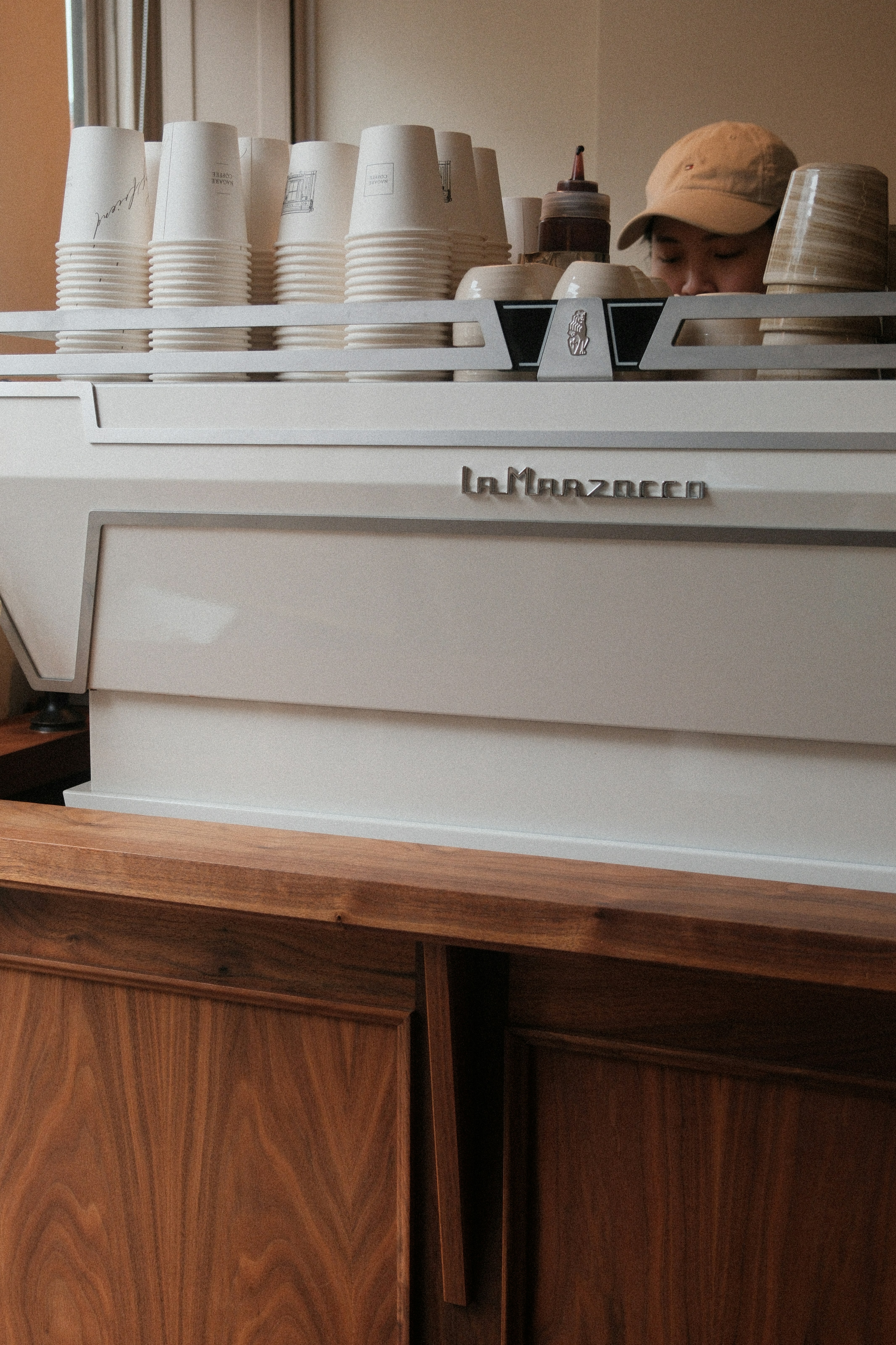 A barista prepares drinks behind a coffee machine.
