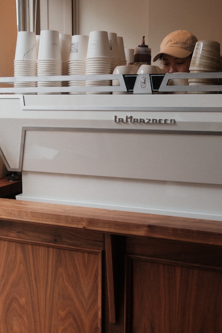 Student barista preparing drinks behind a coffee shop counter