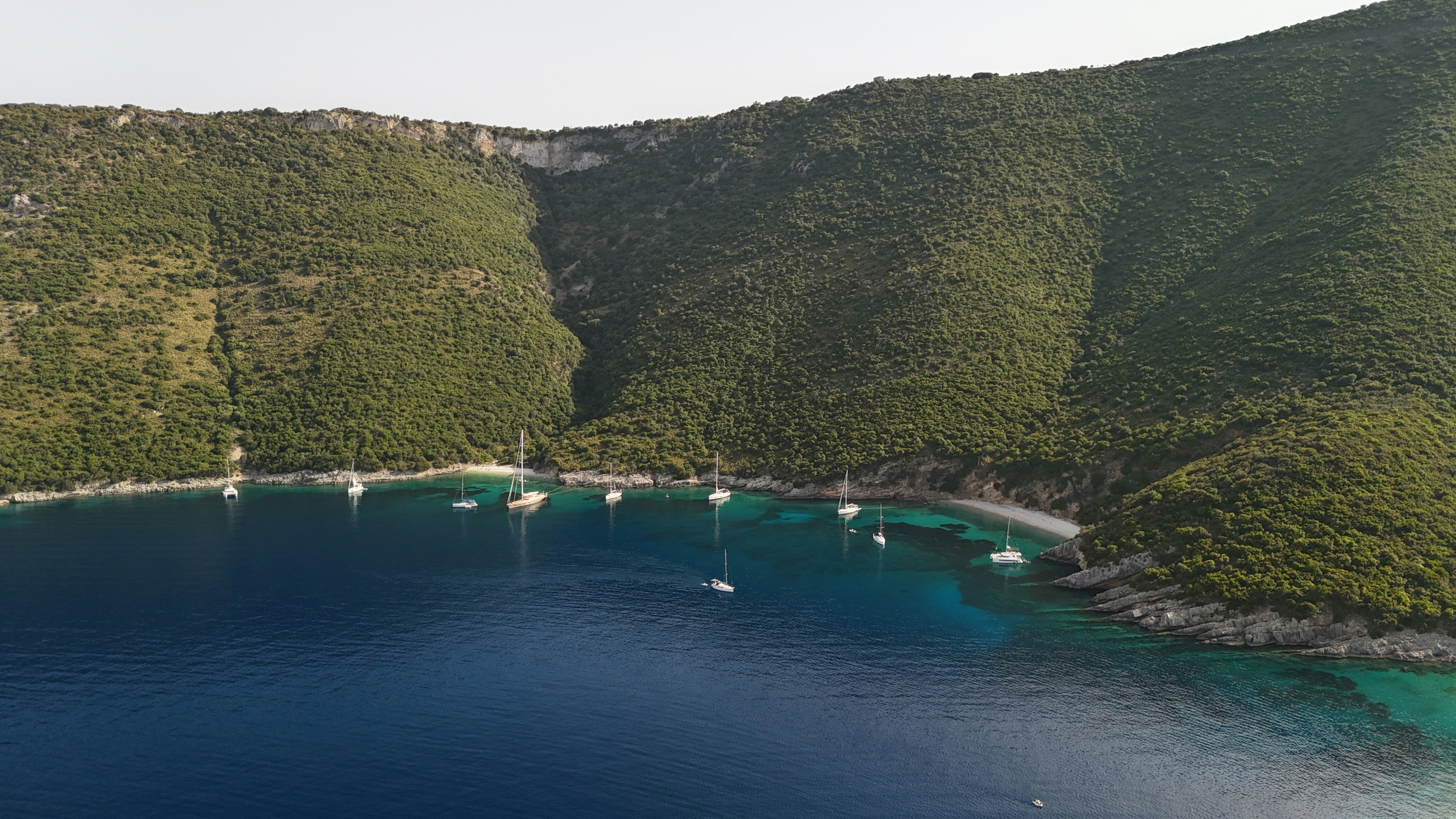 Boats anchor in a scenic bay.
