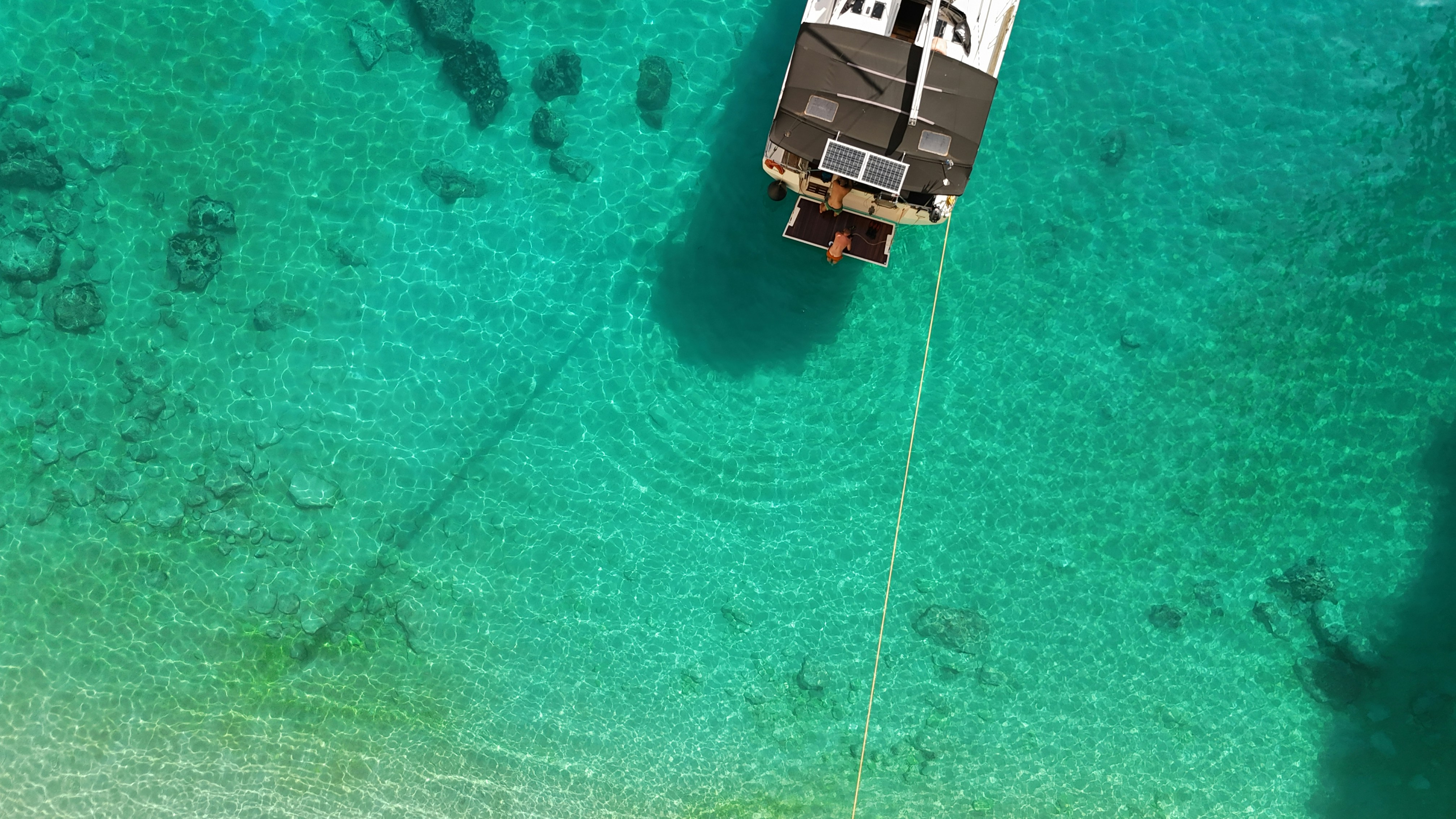 A boat is anchored in clear, turquoise water.