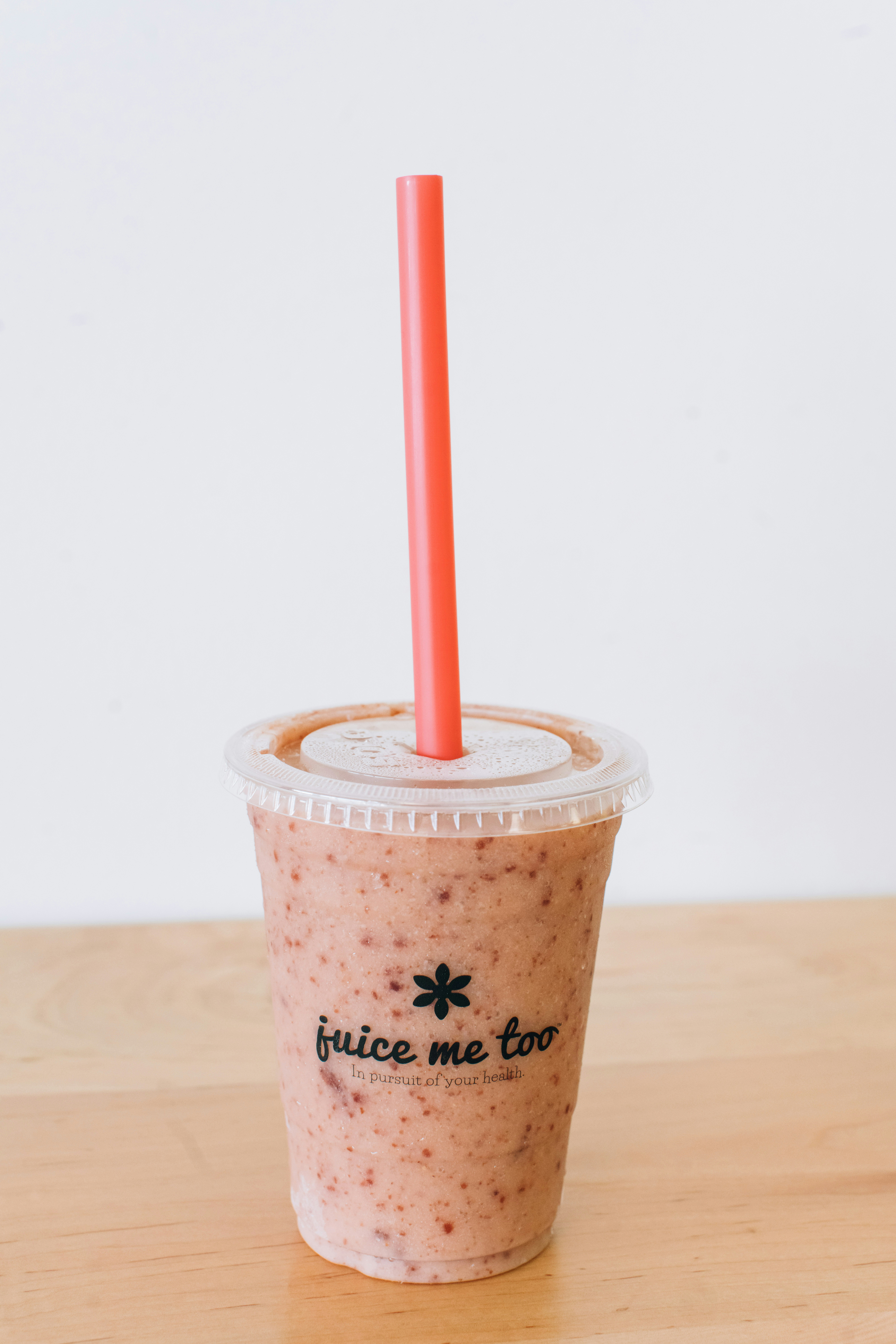 A smoothie with a straw sits on a table.