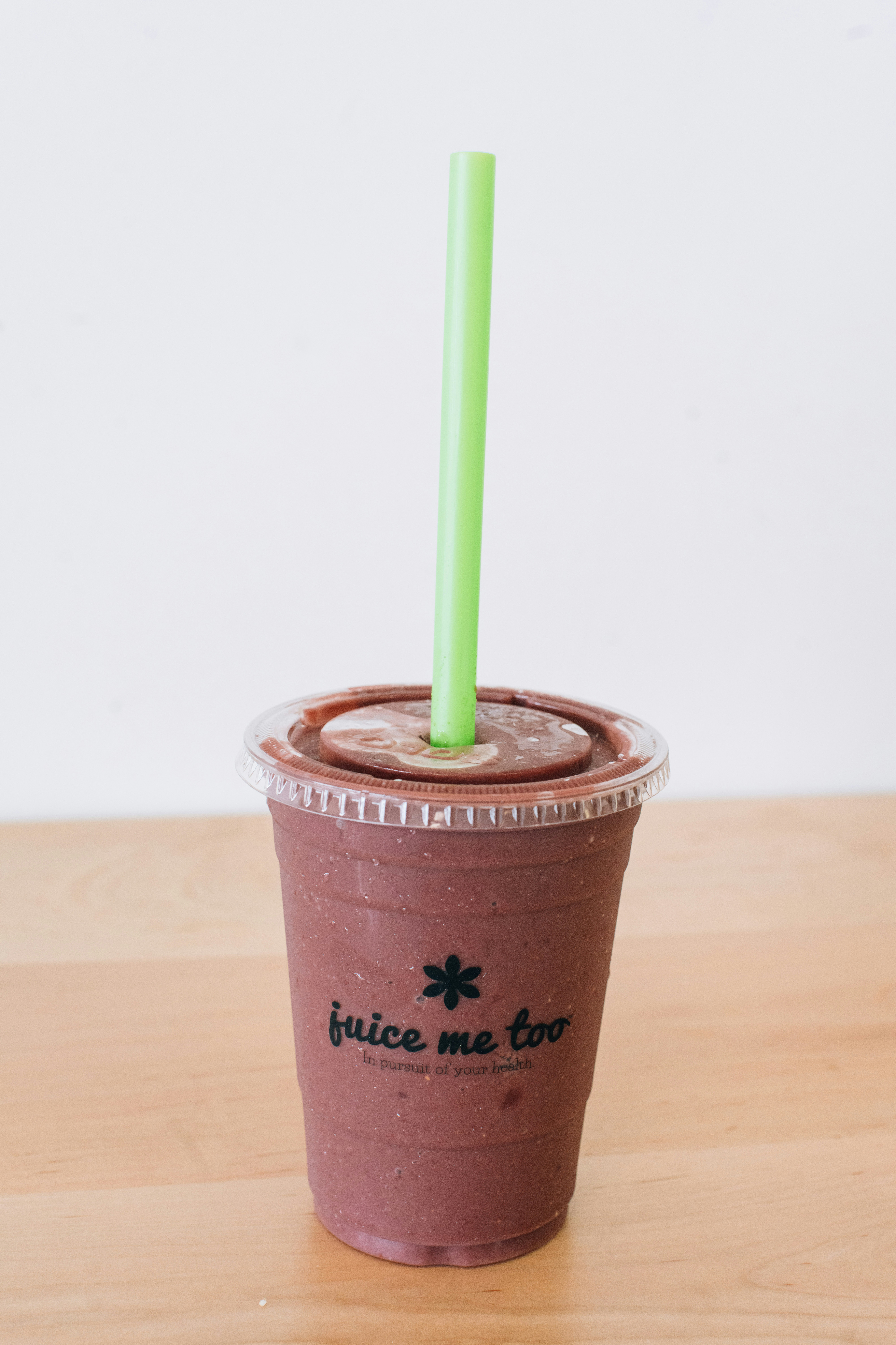 A smoothie with a green straw is shown.