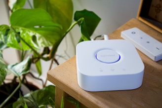 Smart home hub and remote on a wooden table.