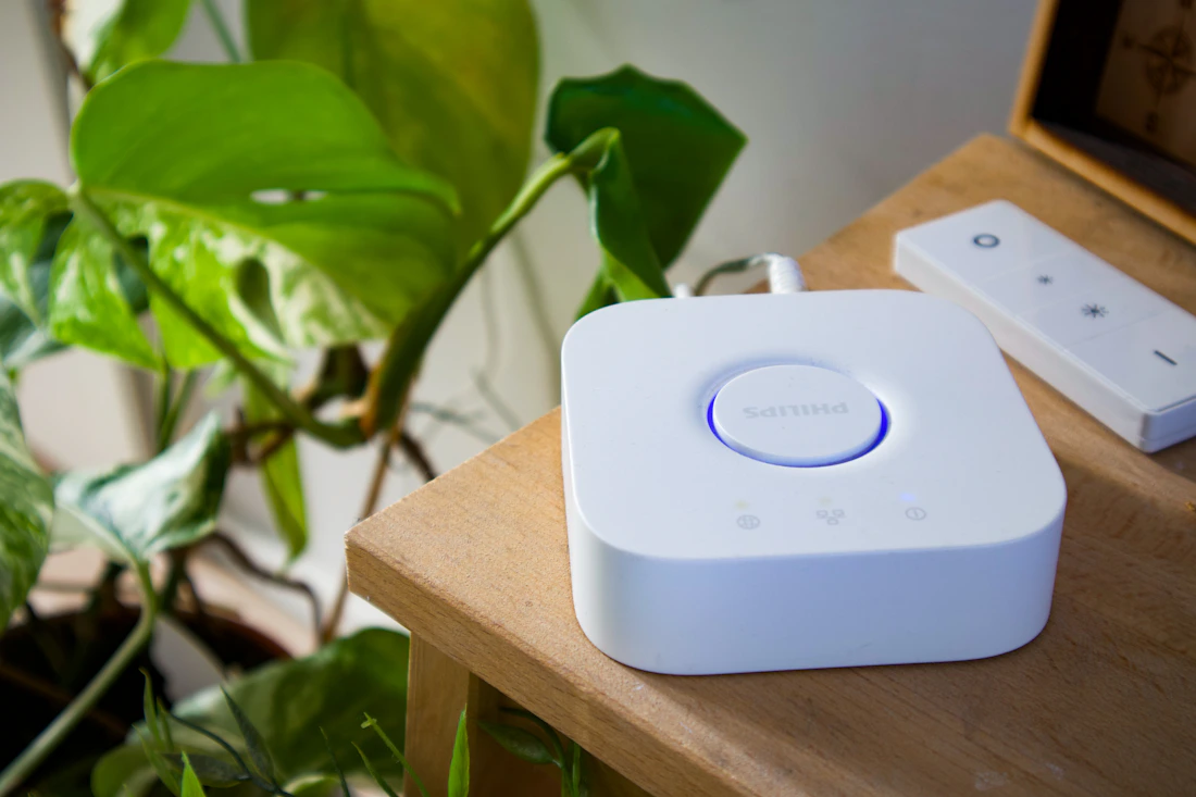 Smart home hub and remote control displayed on a wooden table