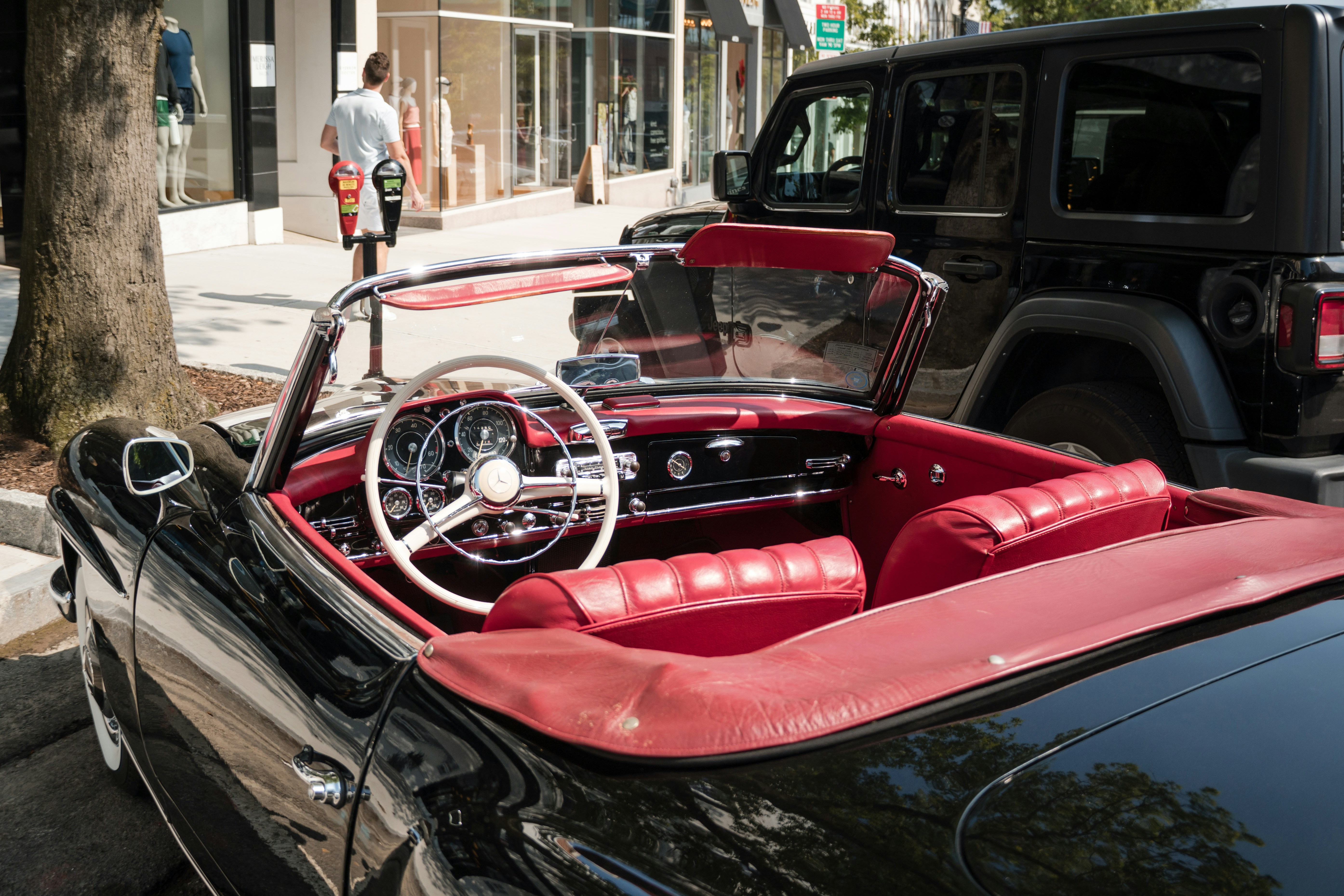 Classic convertible car parked on a city street.